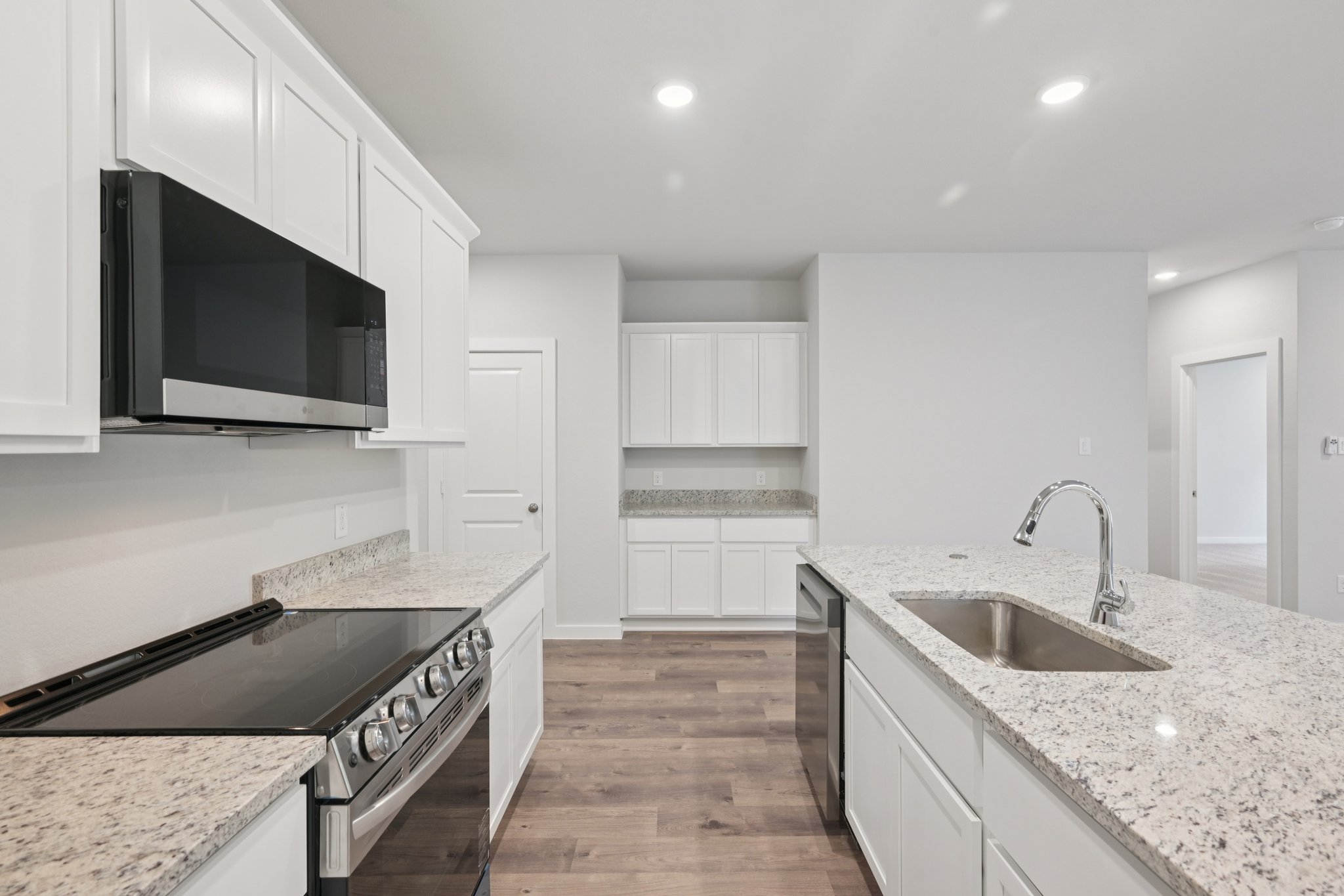 A kitchen with white cabinets.