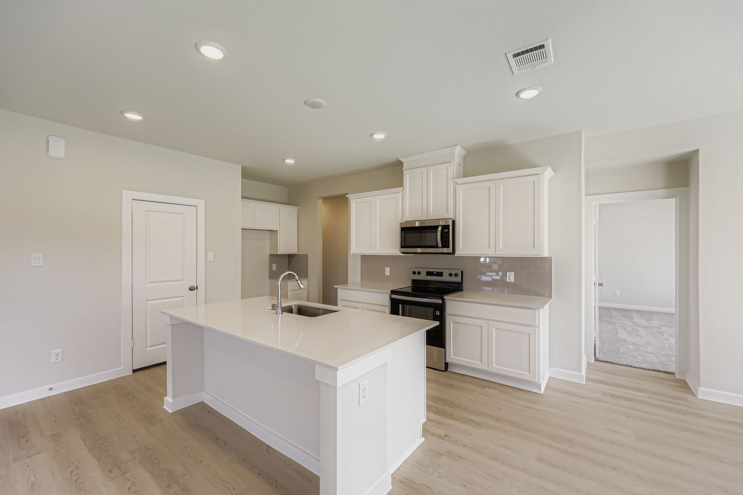 A kitchen with white cabinets.