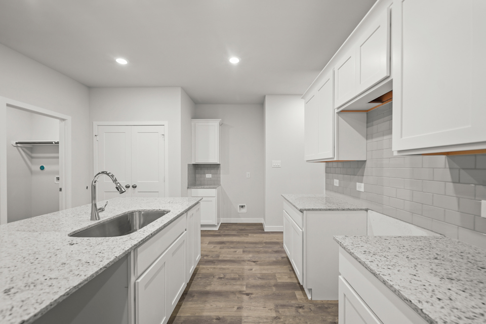 A kitchen with white cabinets.