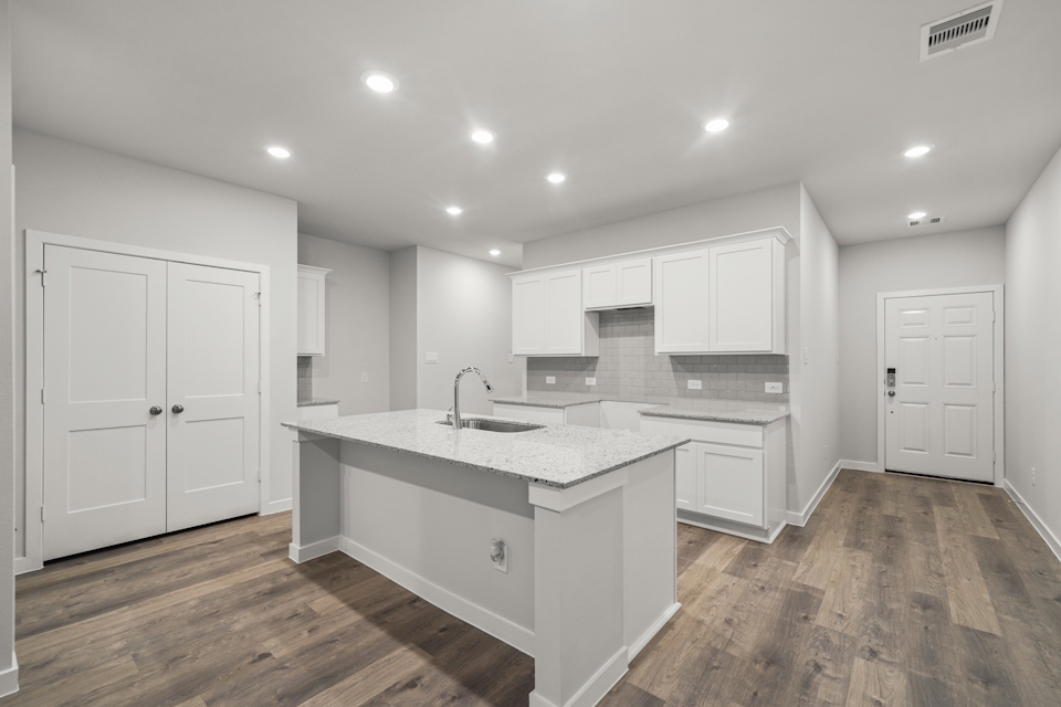 A kitchen with white cabinets.