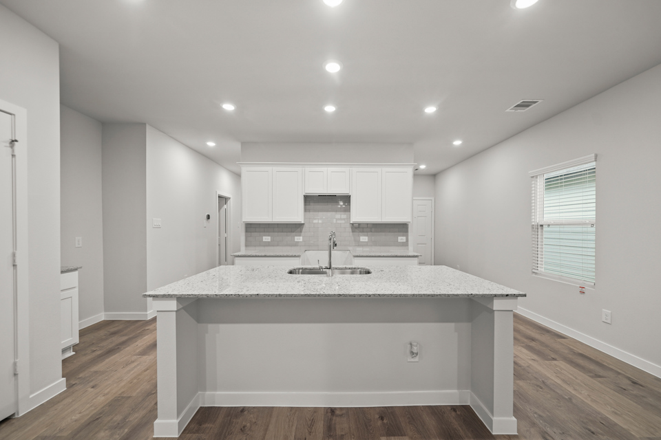A kitchen with white cabinets.