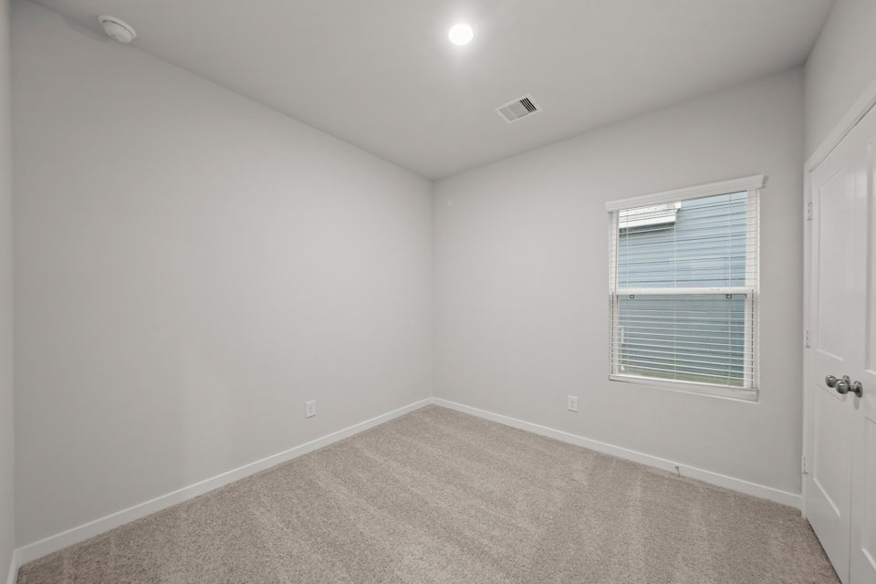 A room with a window and a carpet.