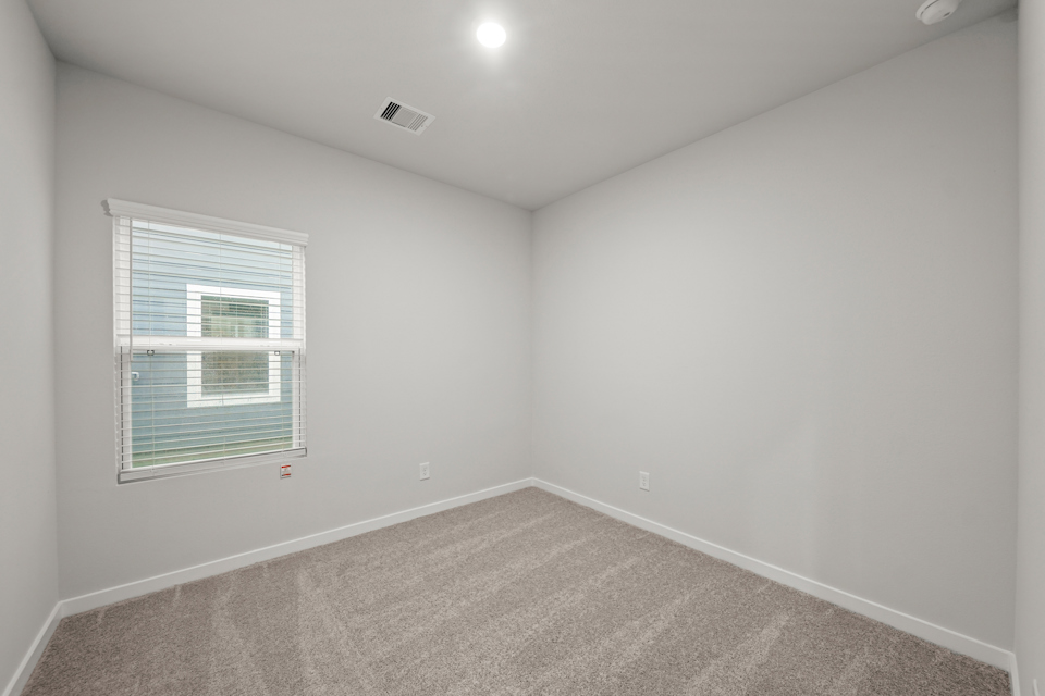 A room with a window and a carpet.