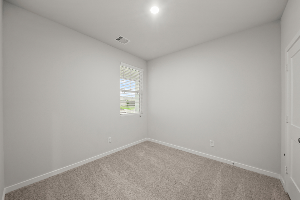 A room with a carpet and a window.