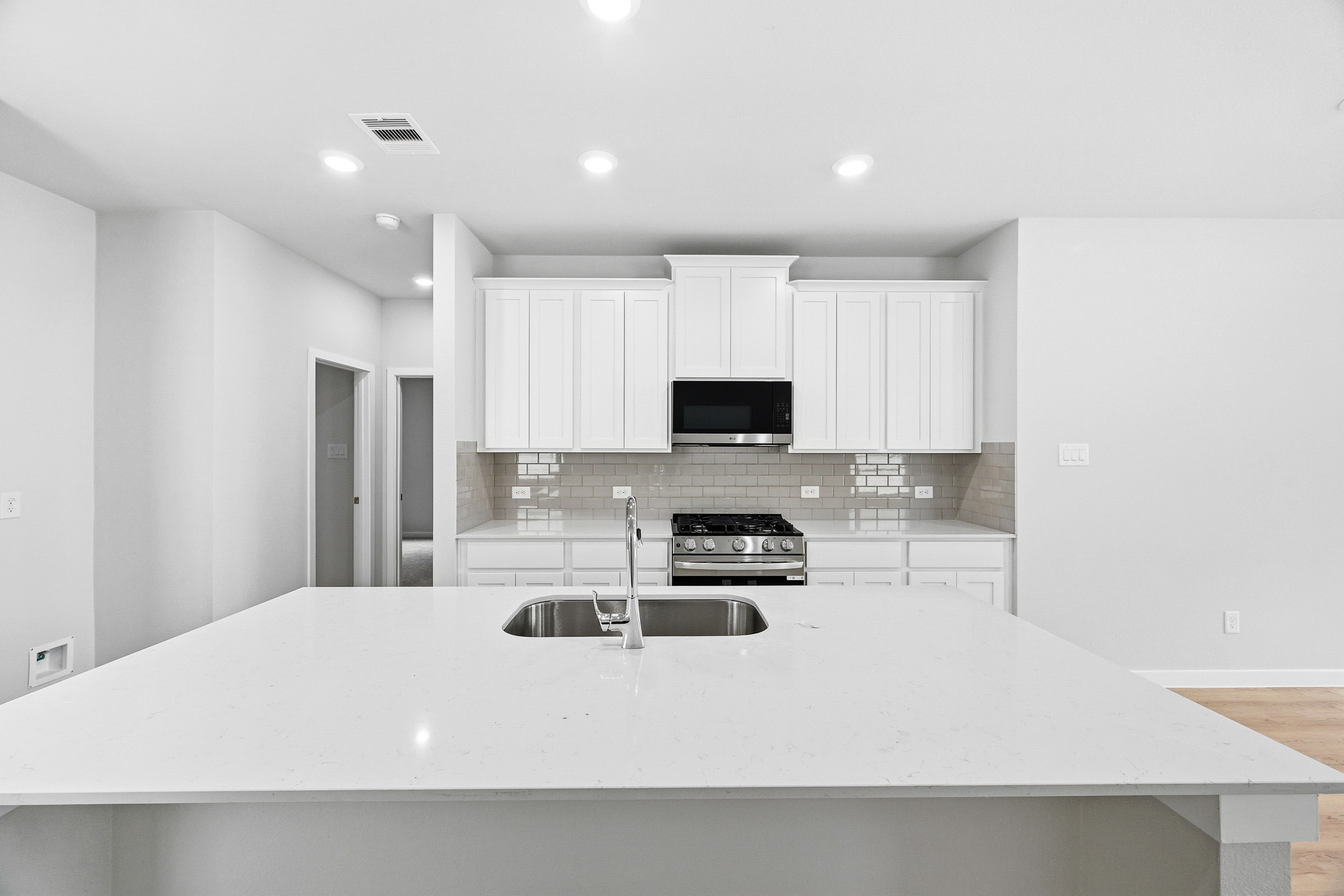 A kitchen with white cabinets.