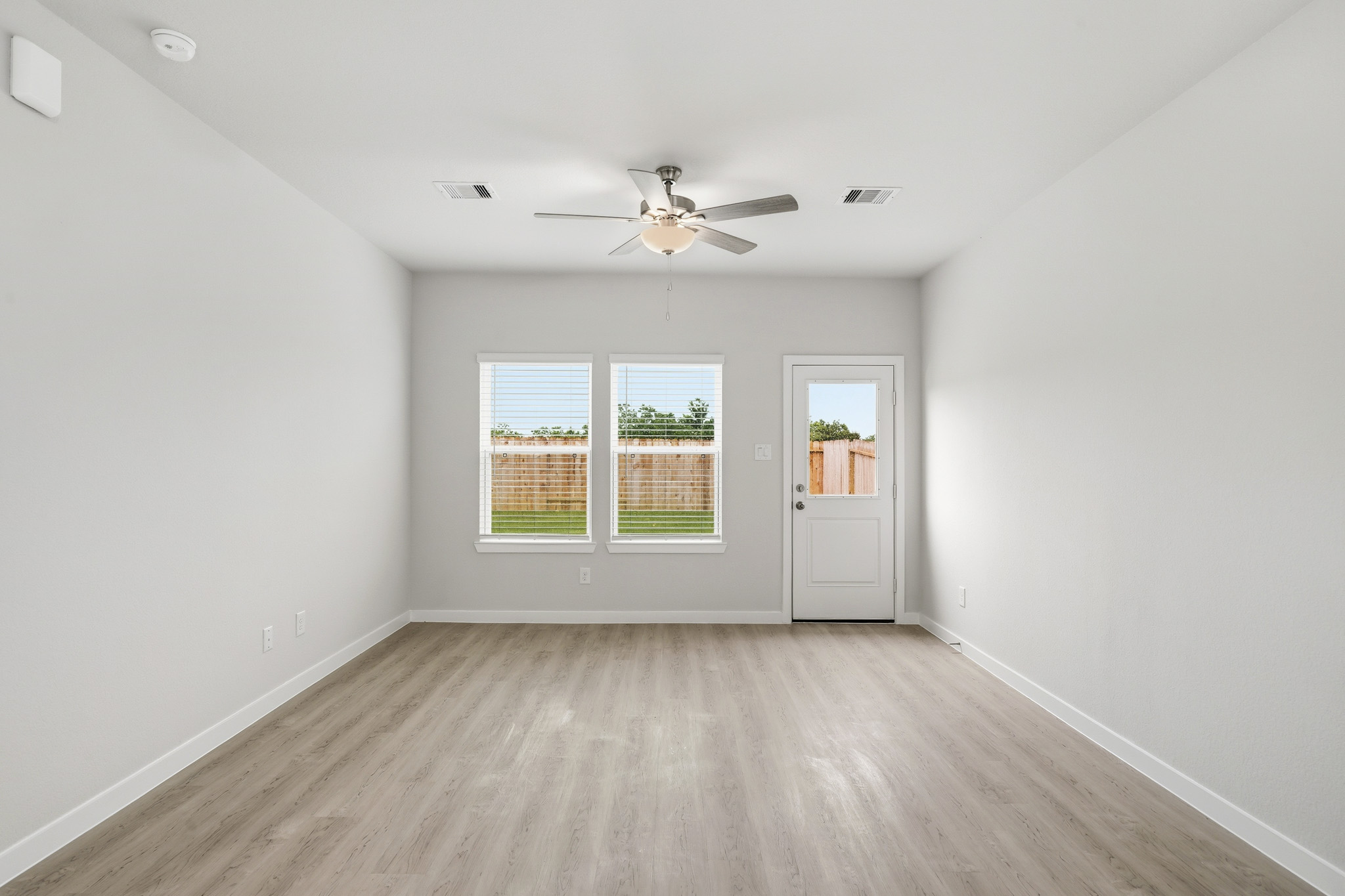 A room with a wood floor and a ceiling fan.