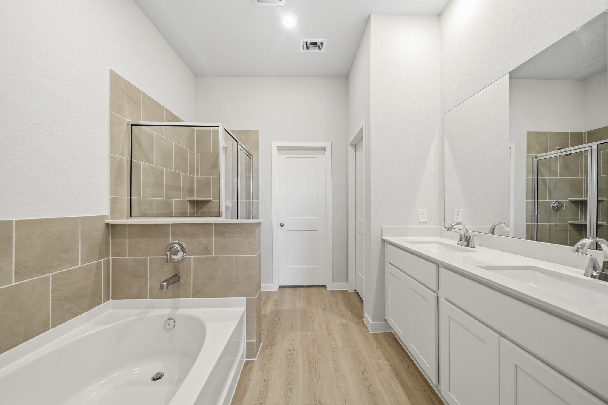 A bathroom with a tub sink and mirror.