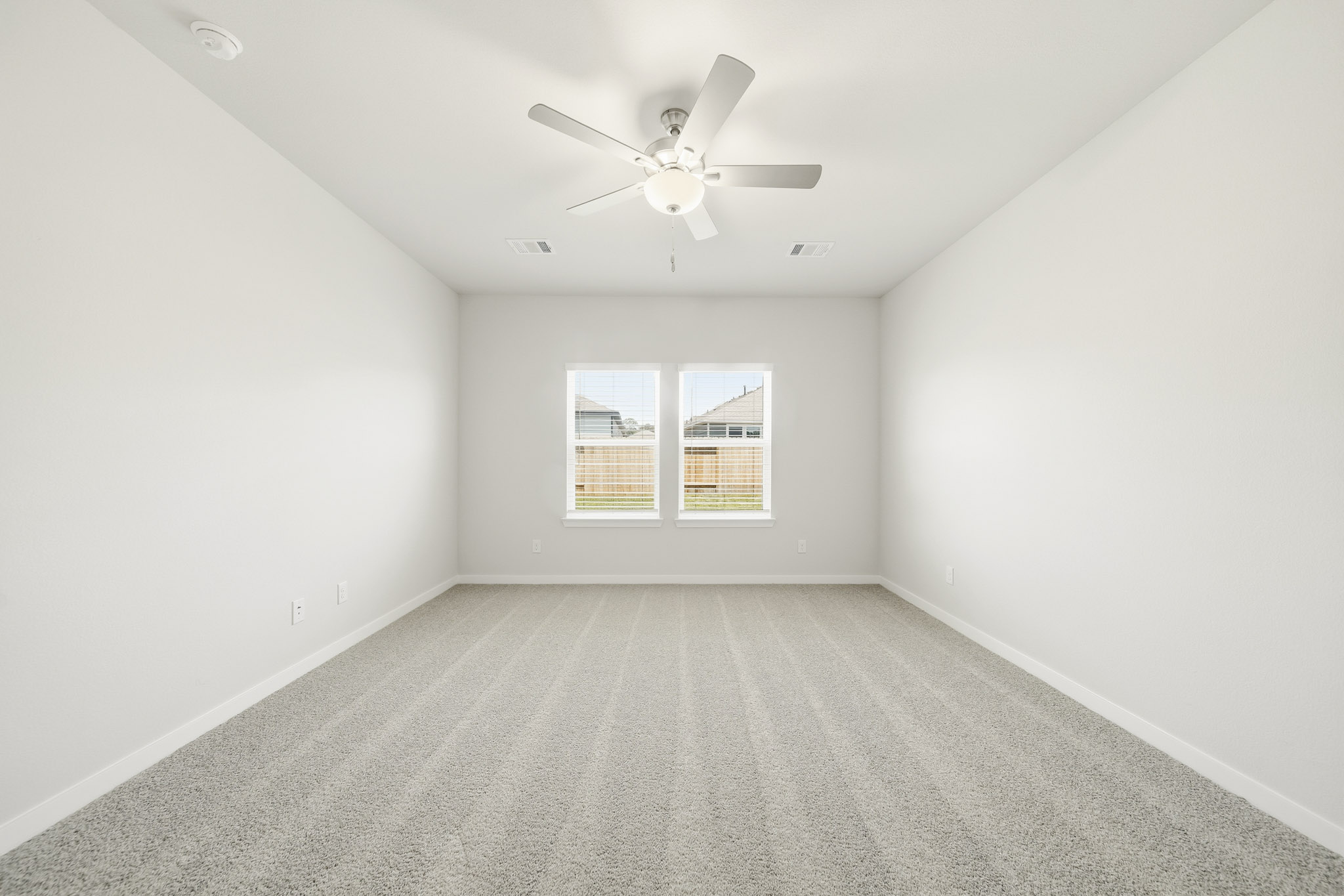 A room with a ceiling fan and a window.