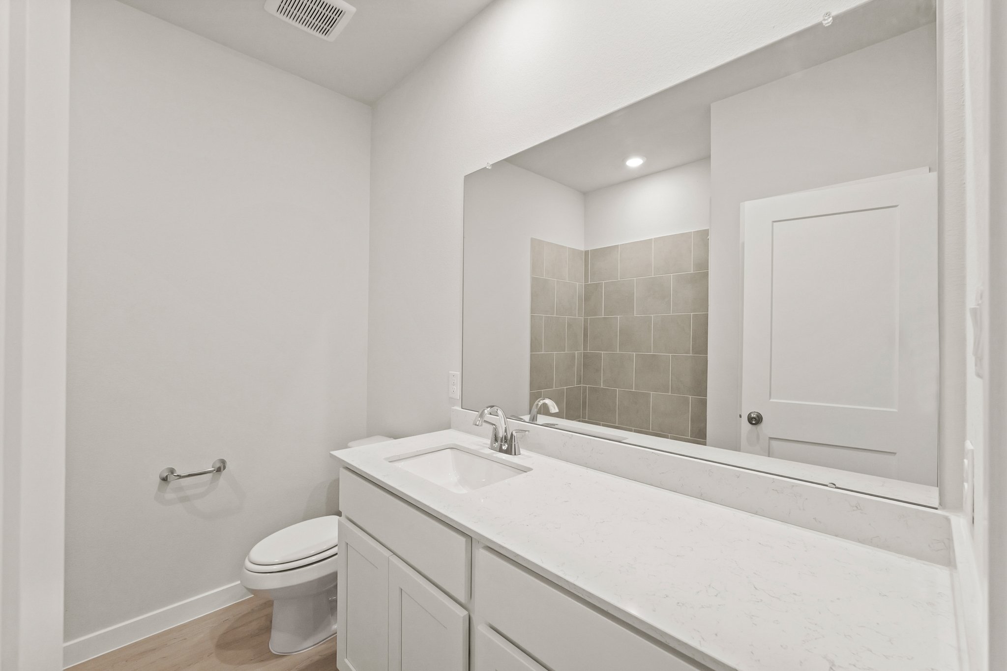 A bathroom with a large mirror.