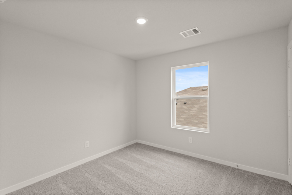 A room with a window and a carpet.