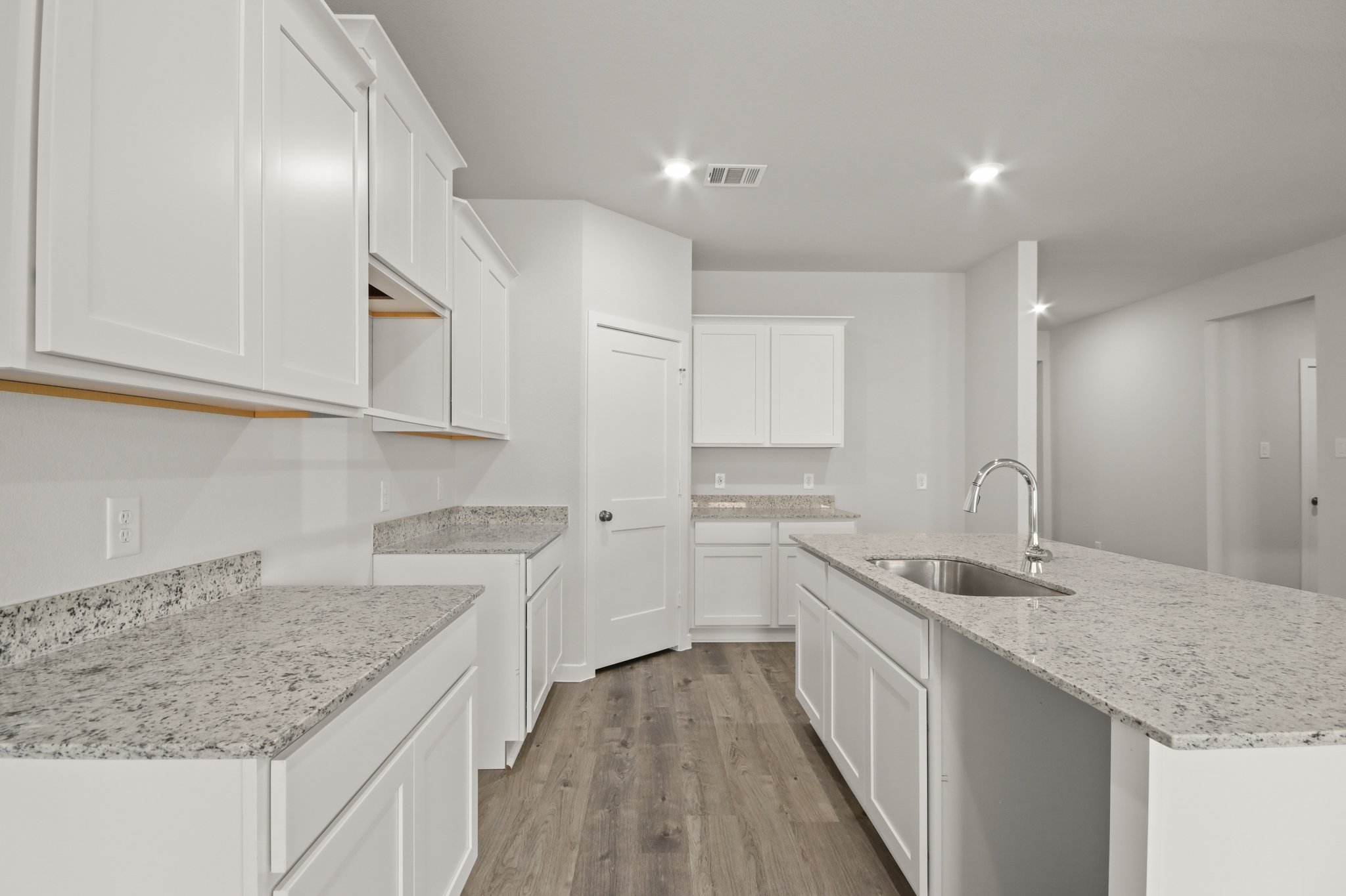 A kitchen with white cabinets.