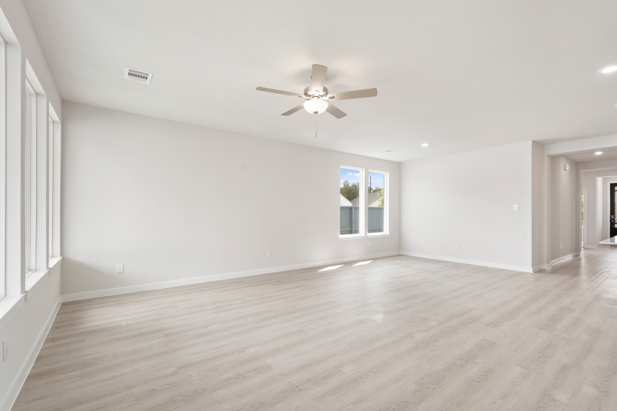 A room with a wood floor and a ceiling fan.