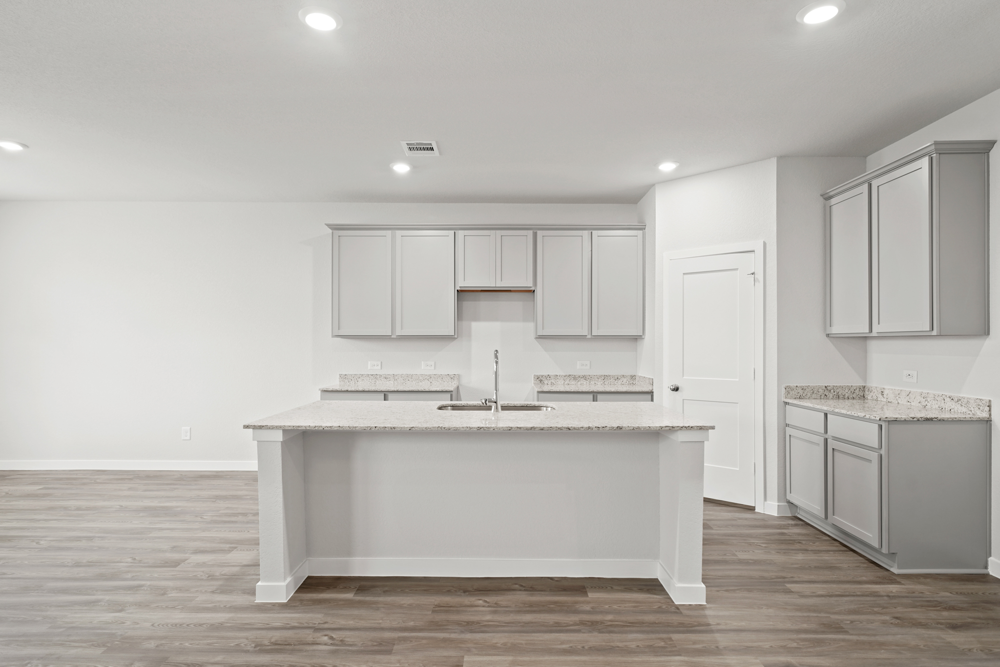 A kitchen with white cabinets.