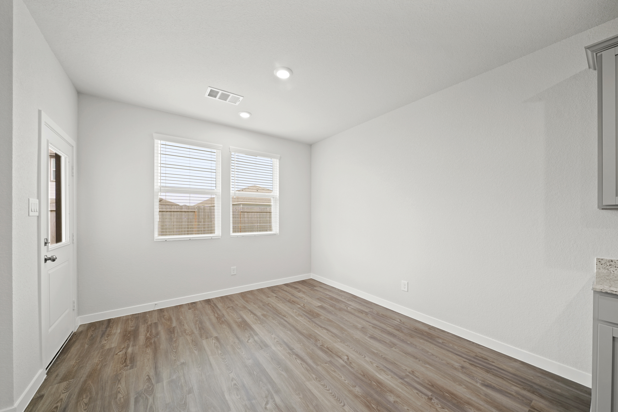 A room with a wood floor and white walls.