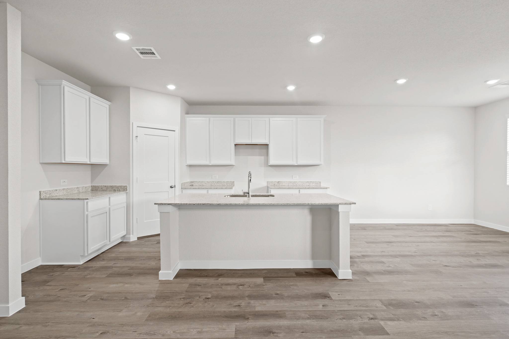 A kitchen with white cabinets.