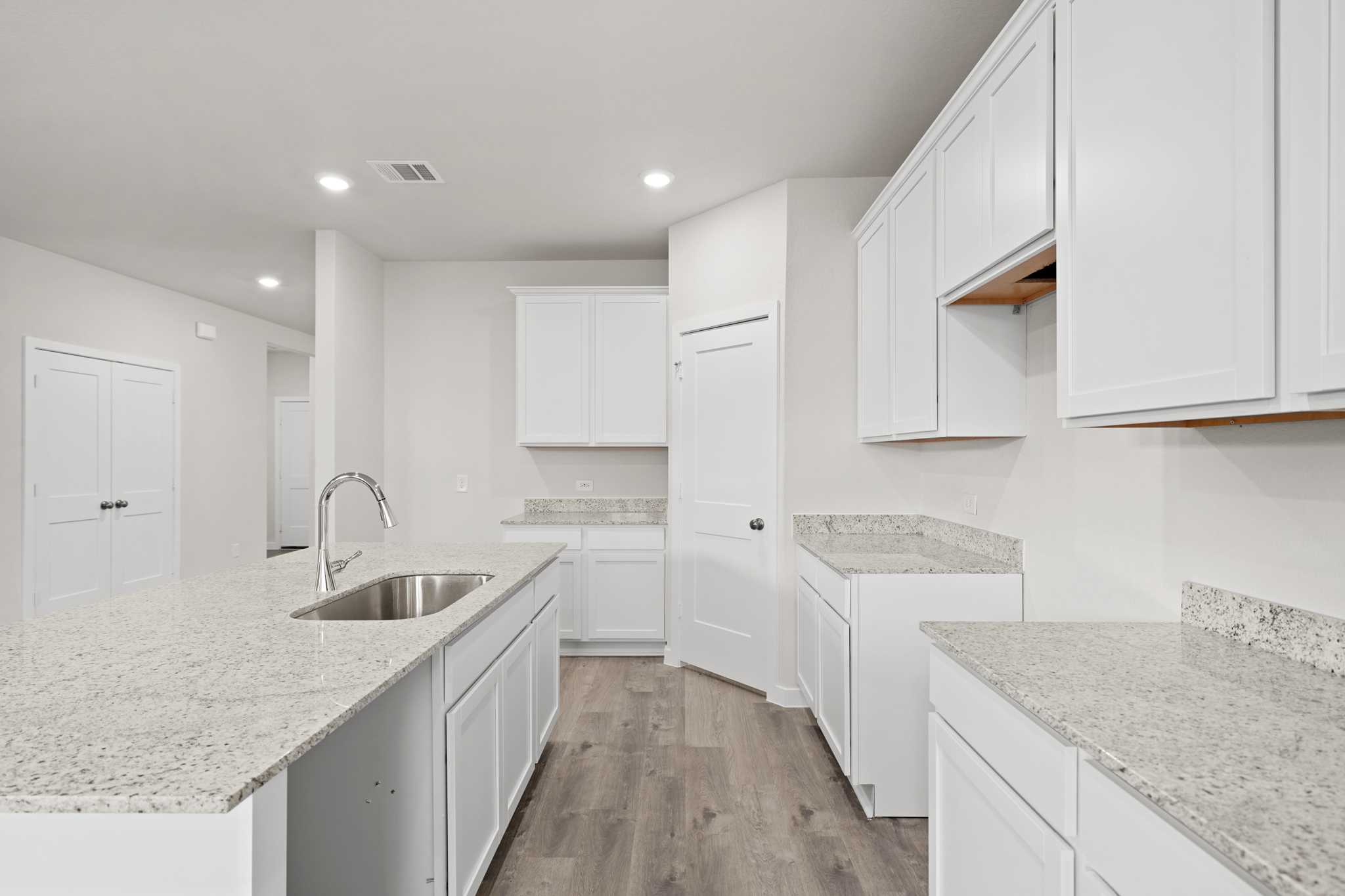 A kitchen with white cabinets.