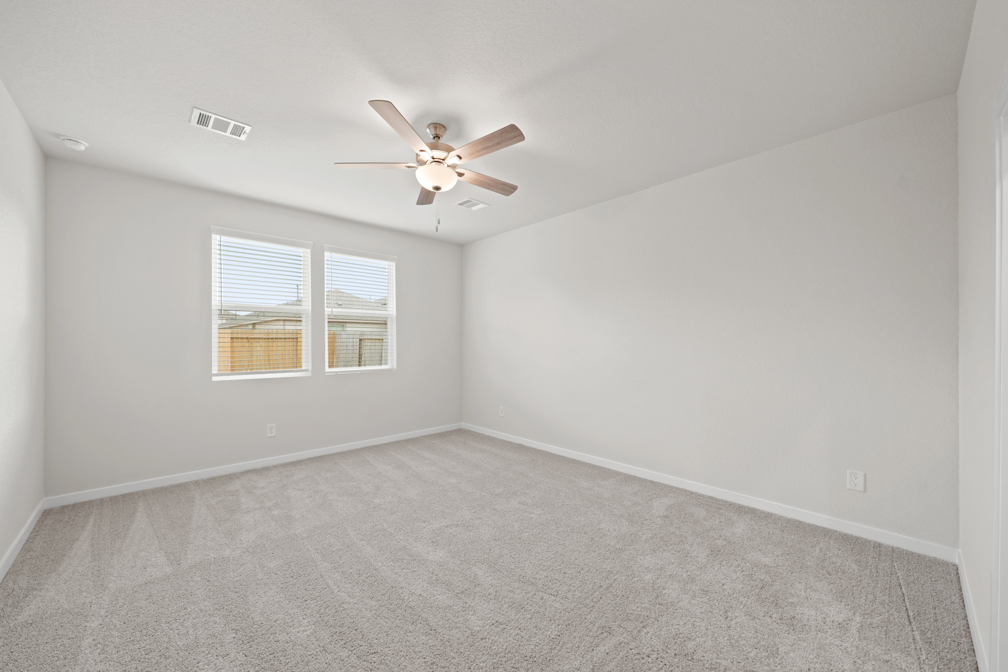 A room with a ceiling fan and a window.