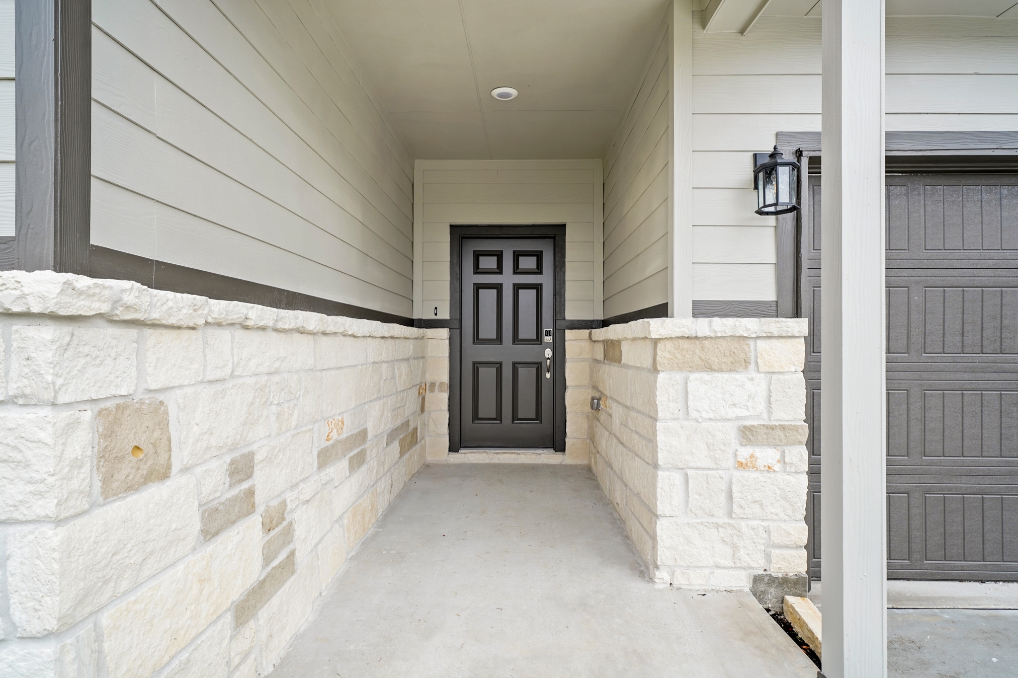 A hallway with stone walls and a door.
