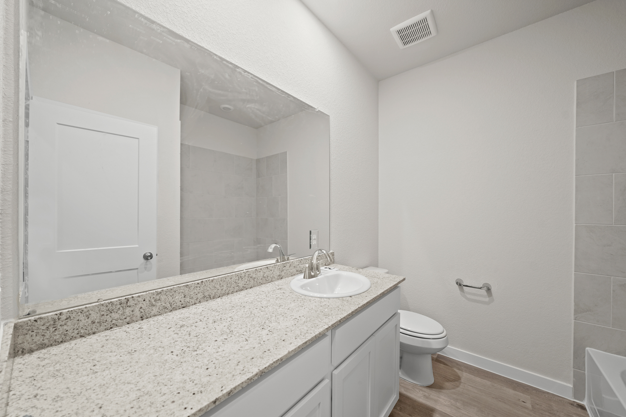 A bathroom with a large mirror.