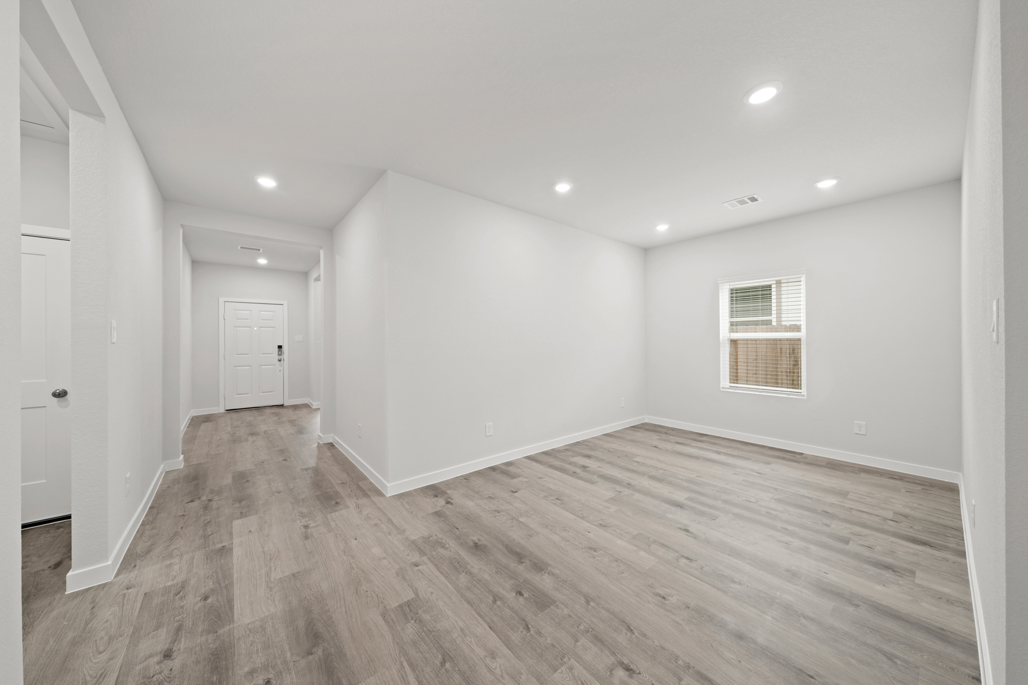 A room with a wood floor and white walls.