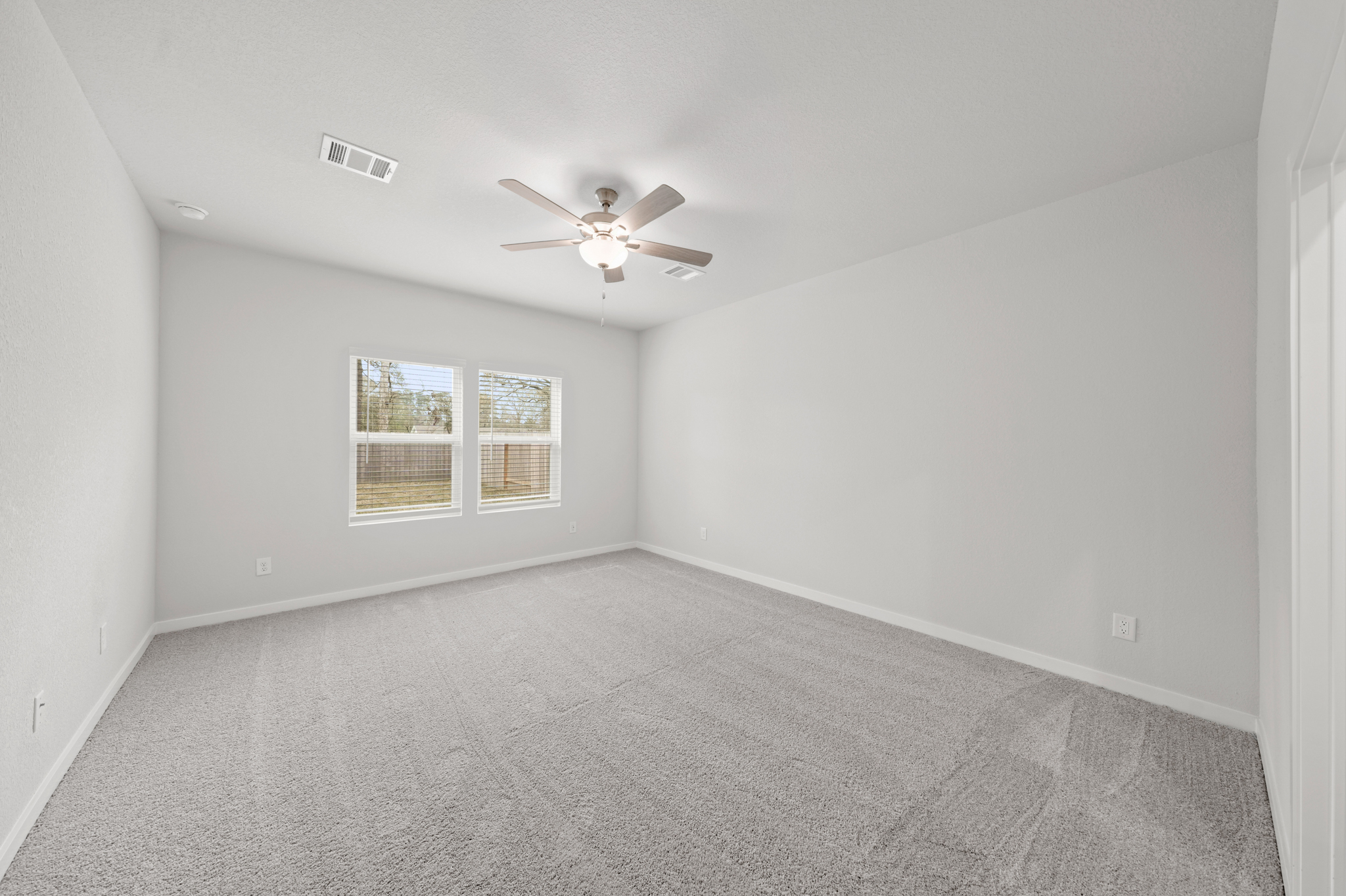 A room with a ceiling fan and a window.