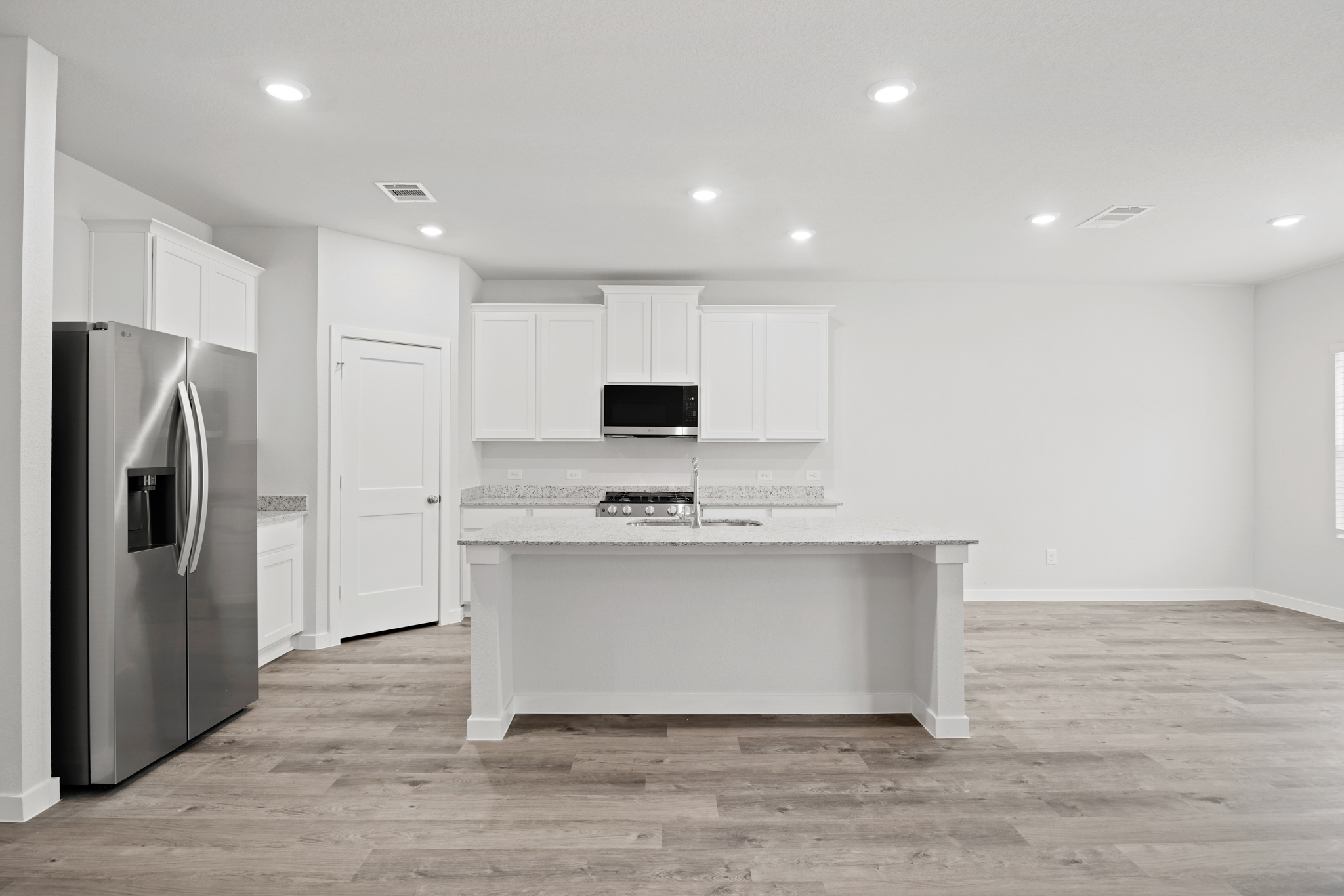 A kitchen with white cabinets.