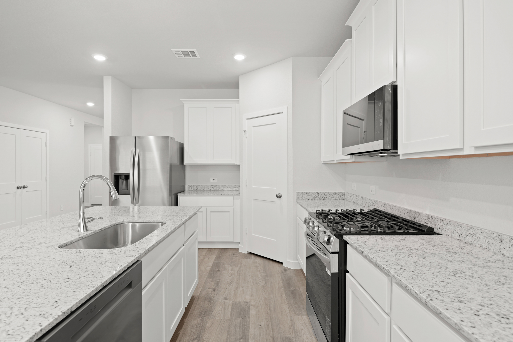 A kitchen with white cabinets.