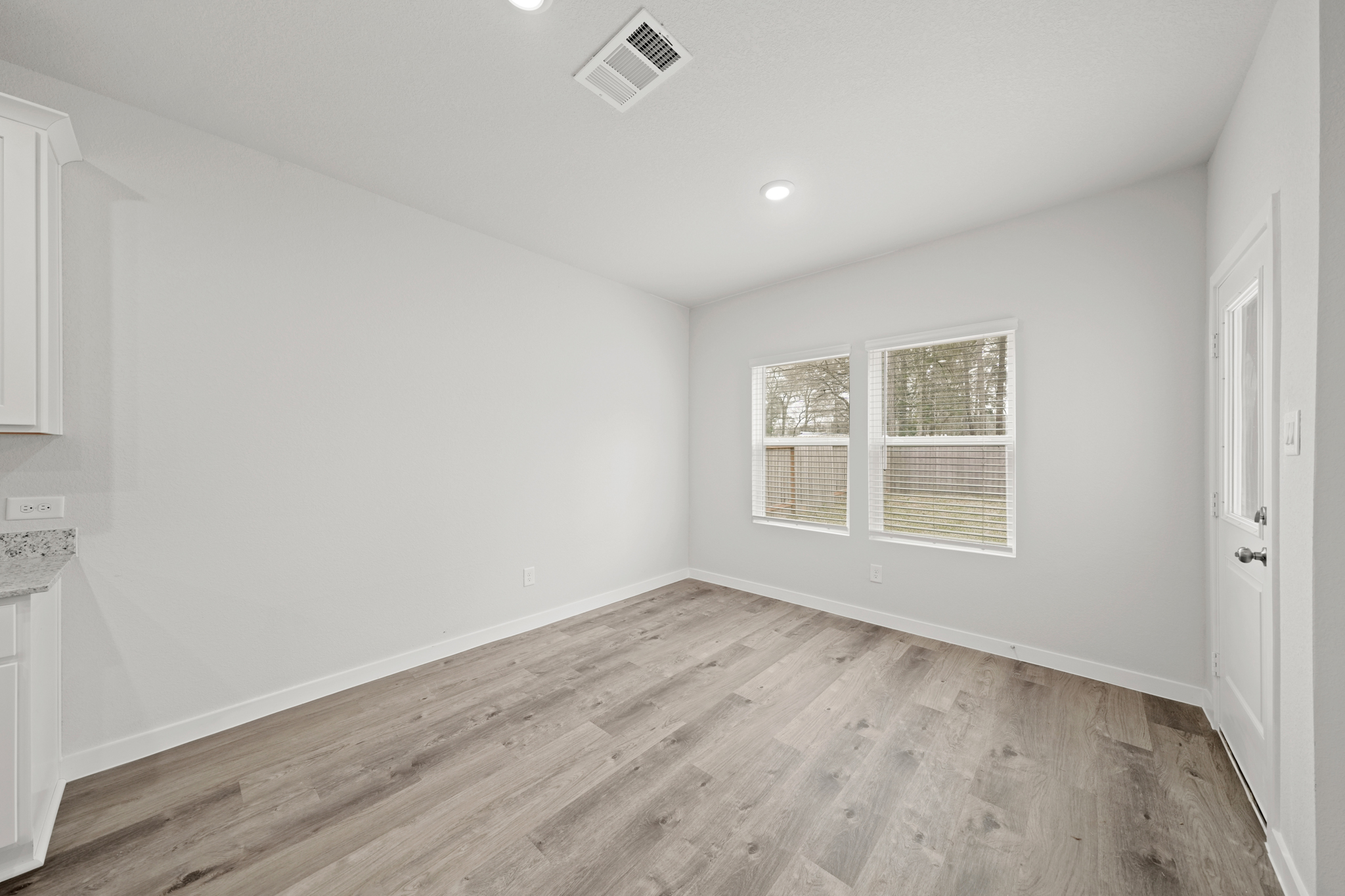 A room with a wood floor and white walls.