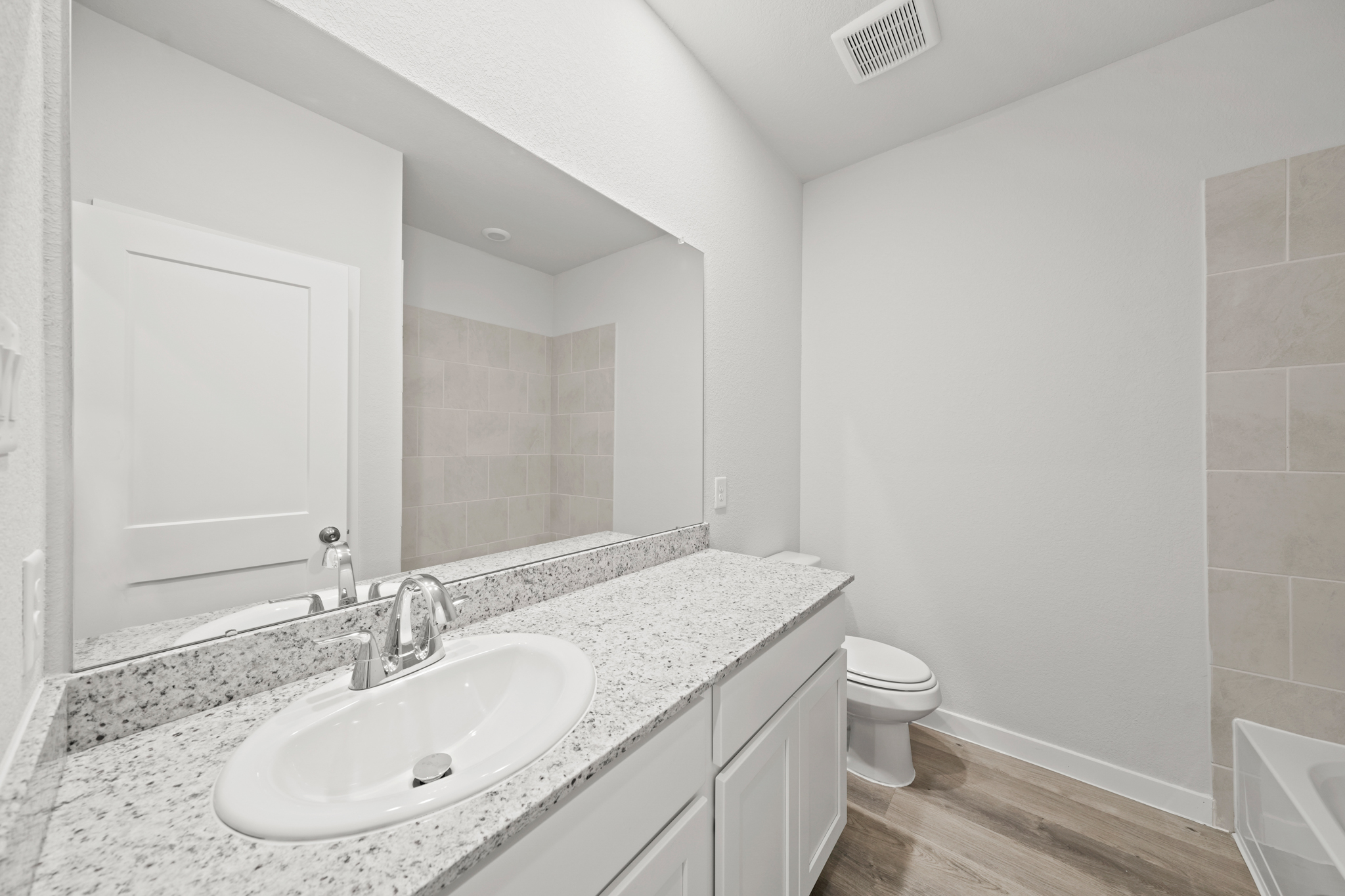 A bathroom with a large mirror.
