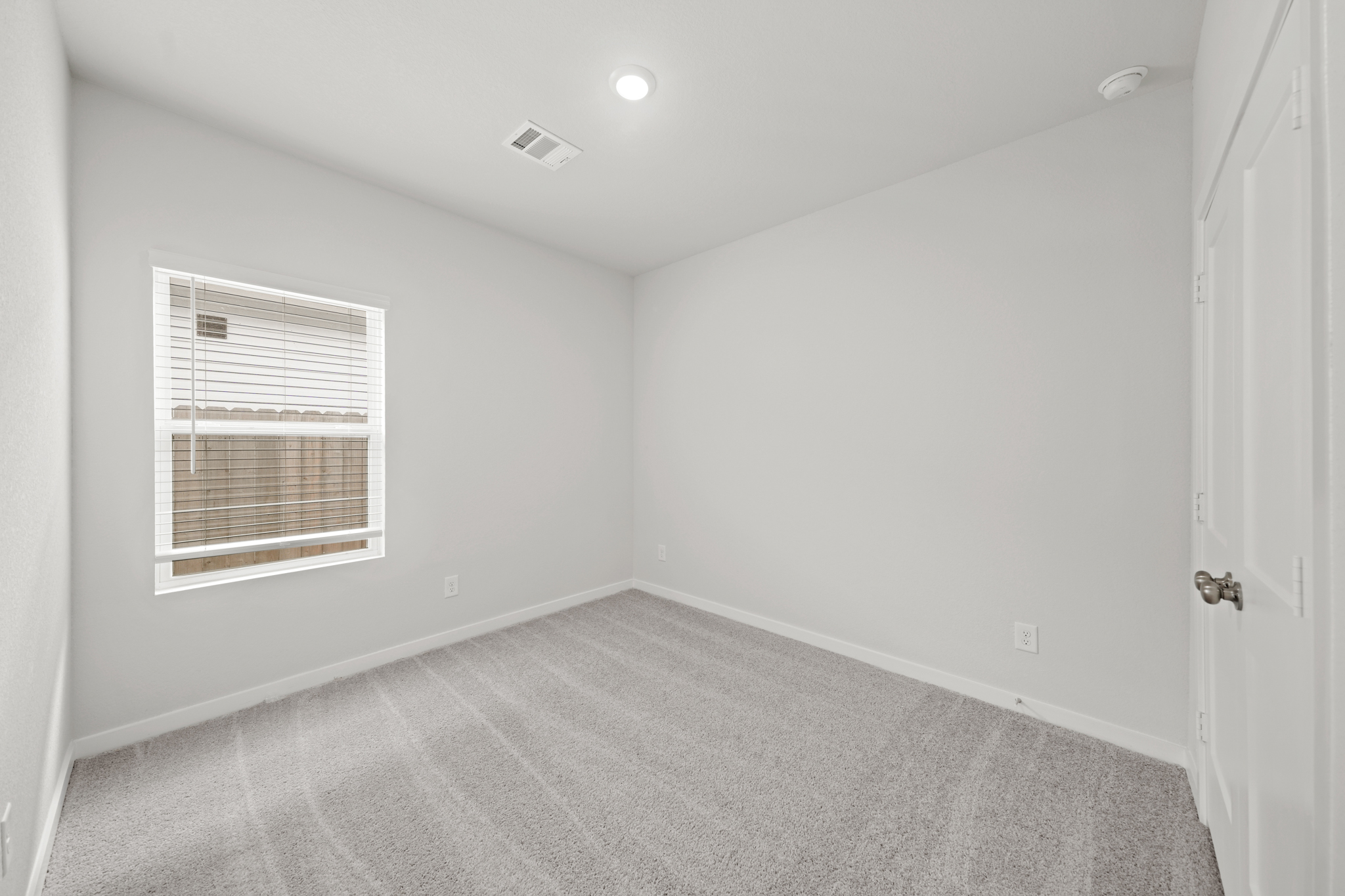 A room with a carpet and a window.