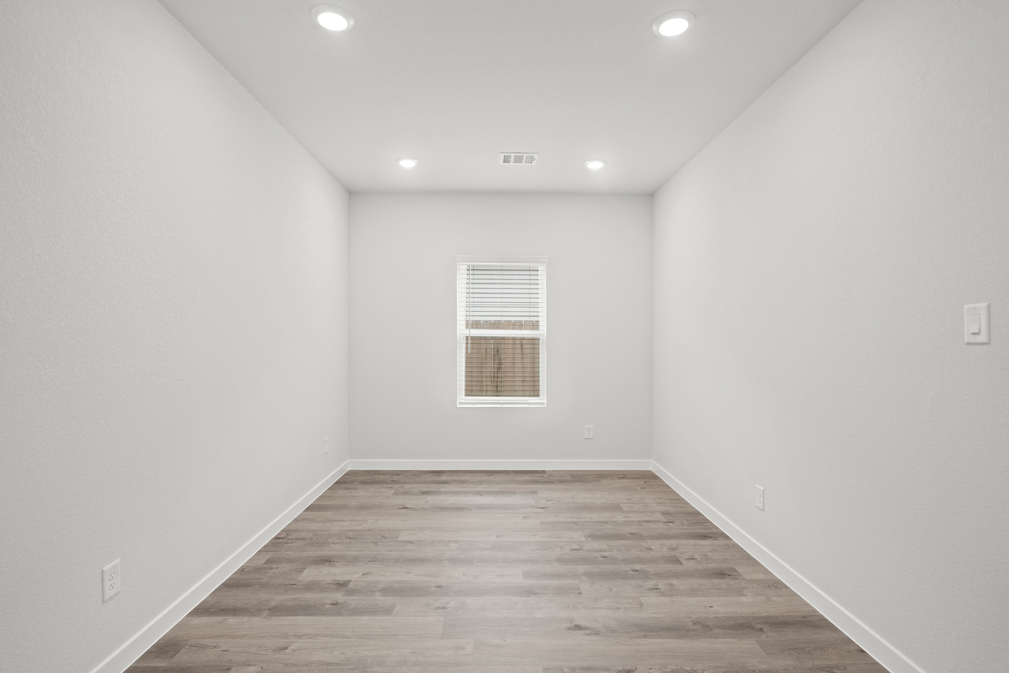 A room with a wood floor and white walls.