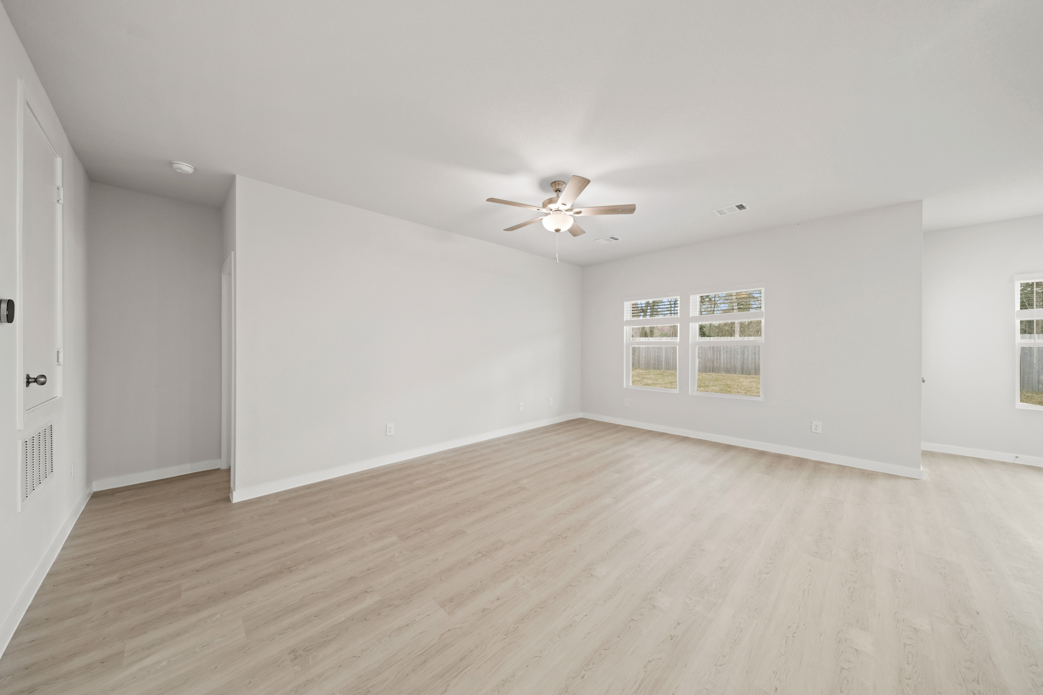 A room with a wood floor and a ceiling fan.