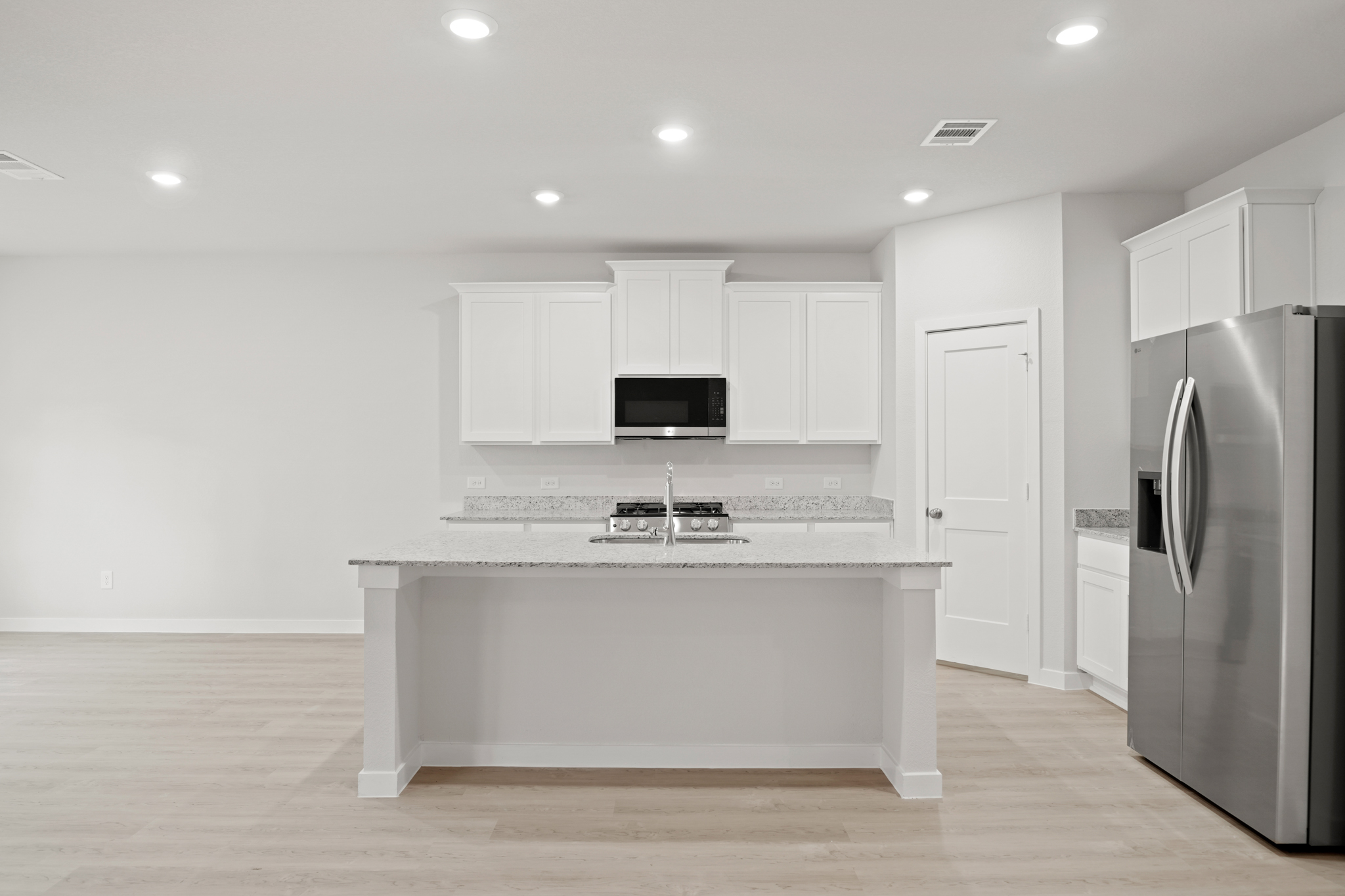 A kitchen with white cabinets.