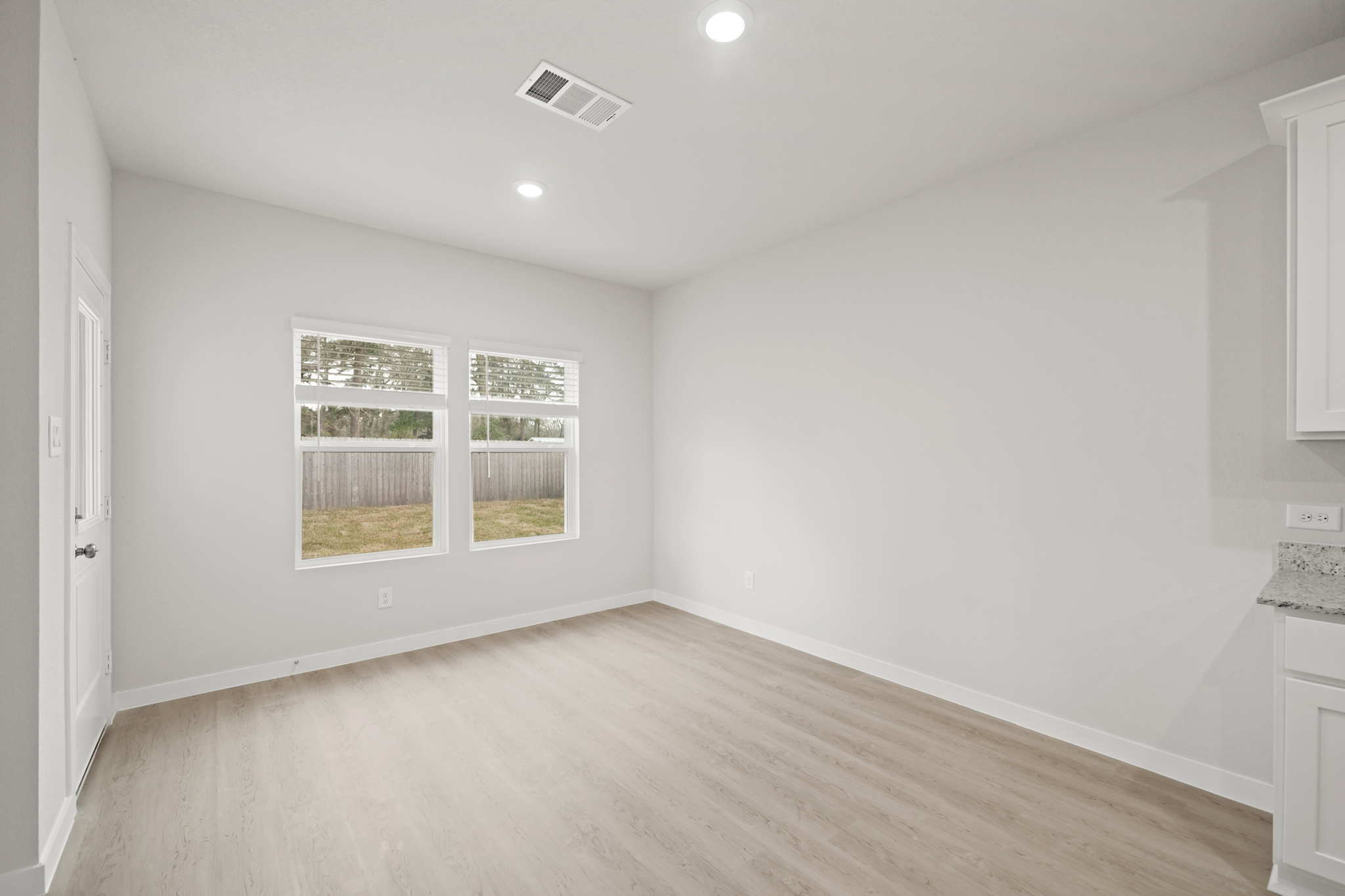 A room with a wood floor and a window.