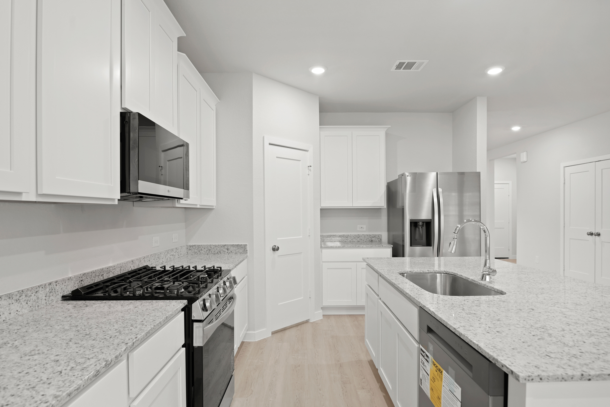 A kitchen with white cabinets.