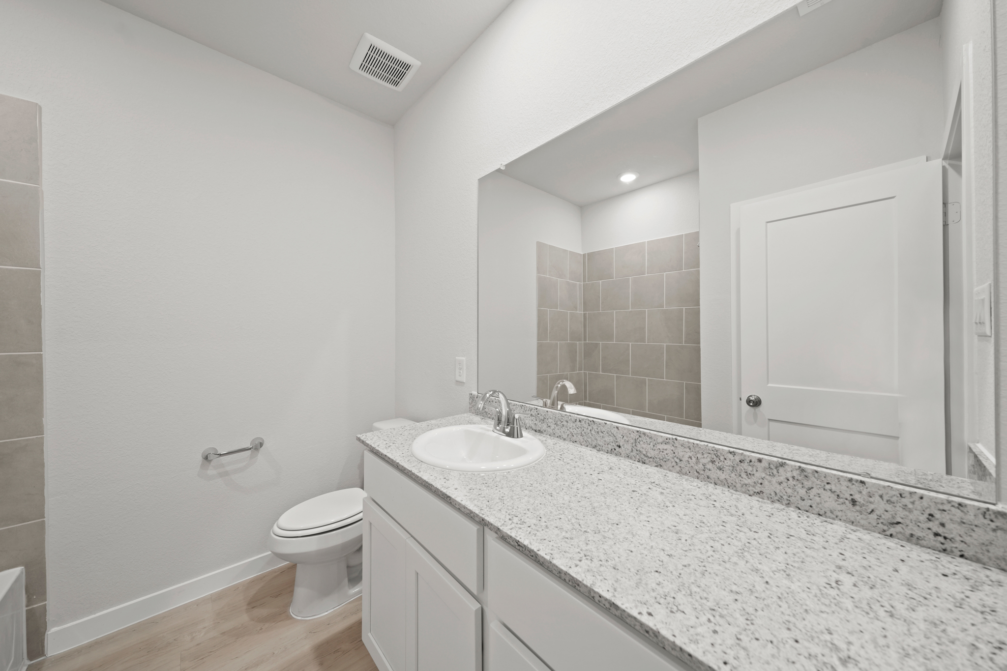 A bathroom with a large mirror.