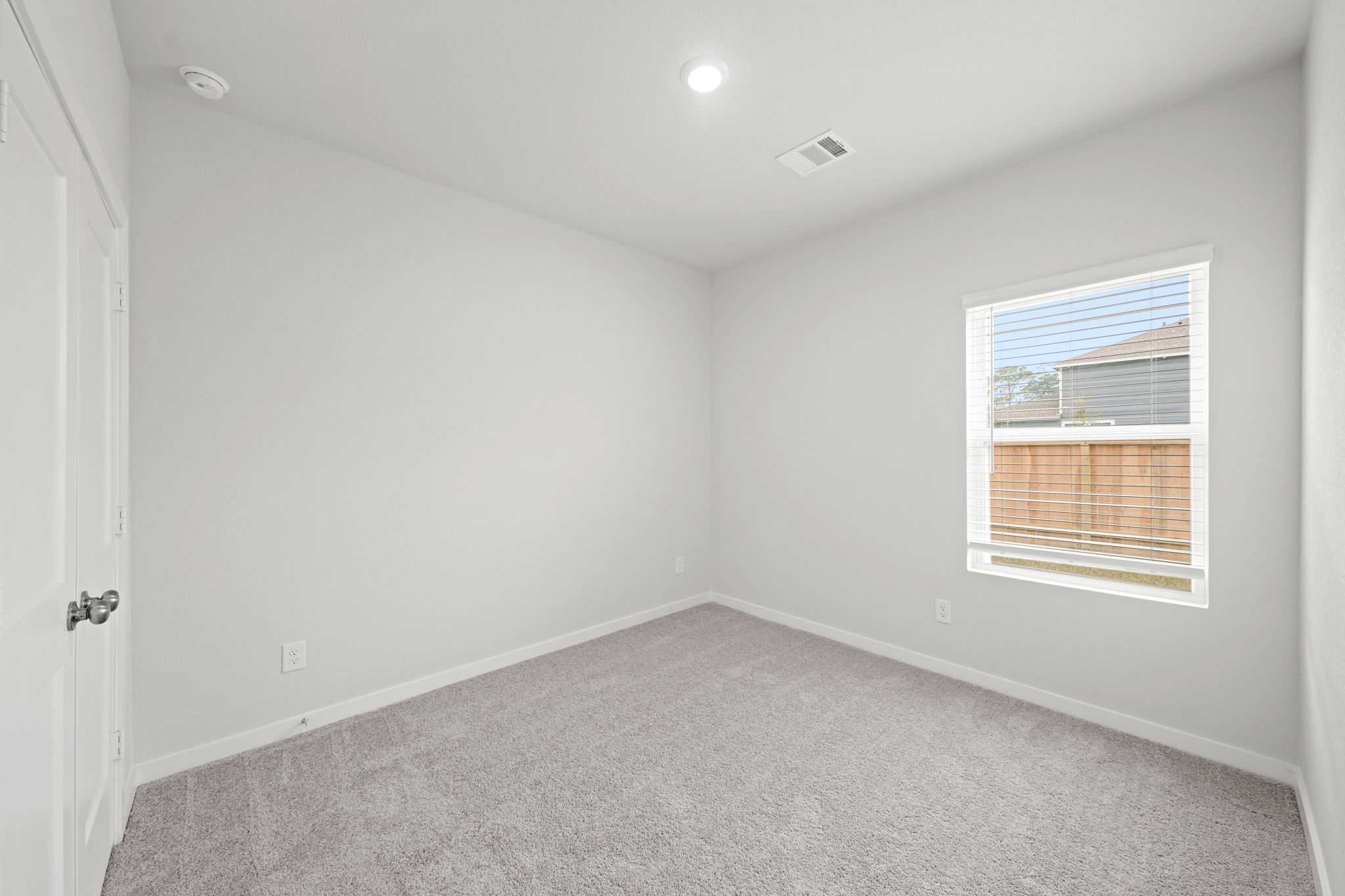 A room with a carpet and a window.