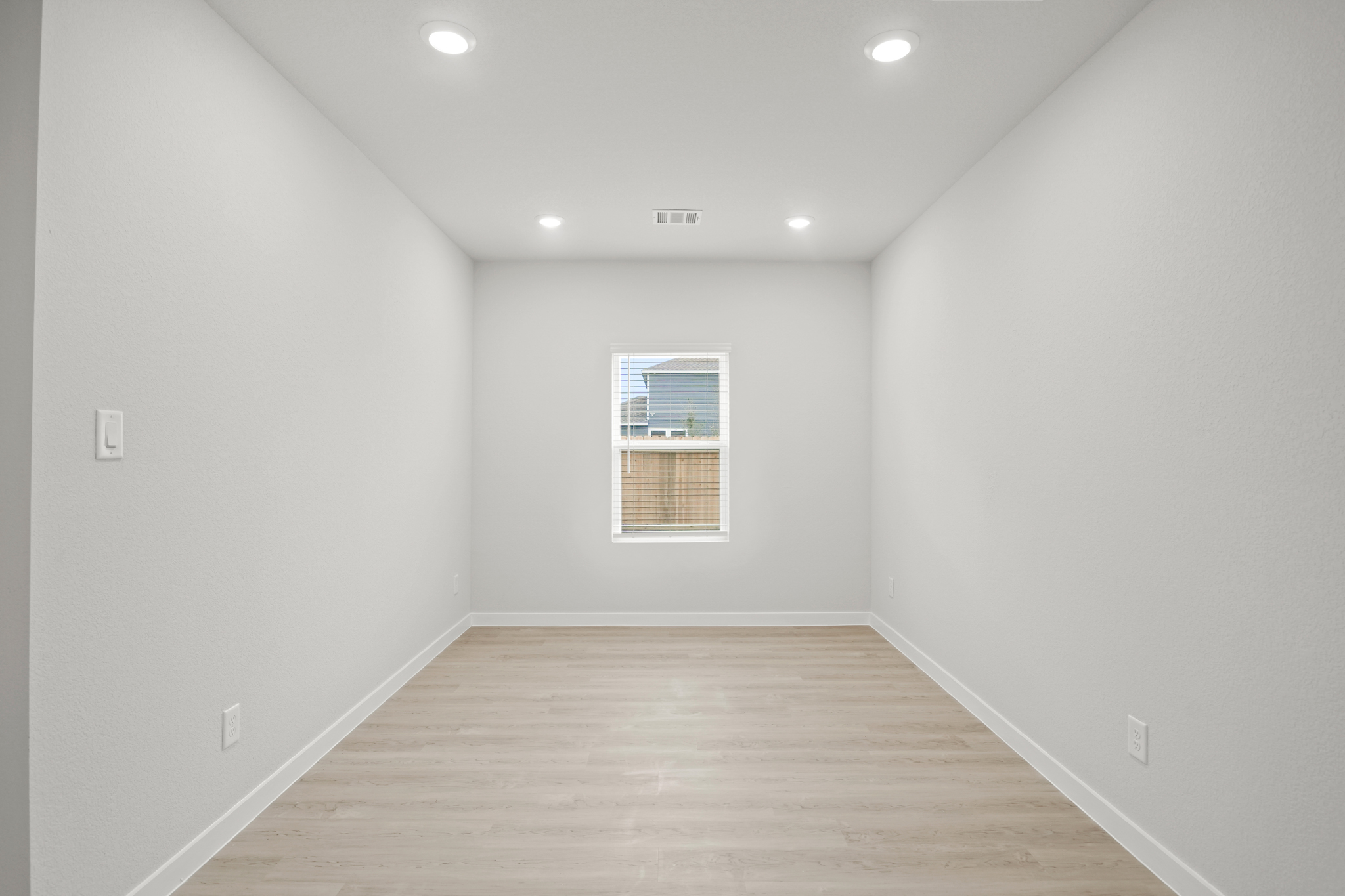 A room with a wood floor and a window.