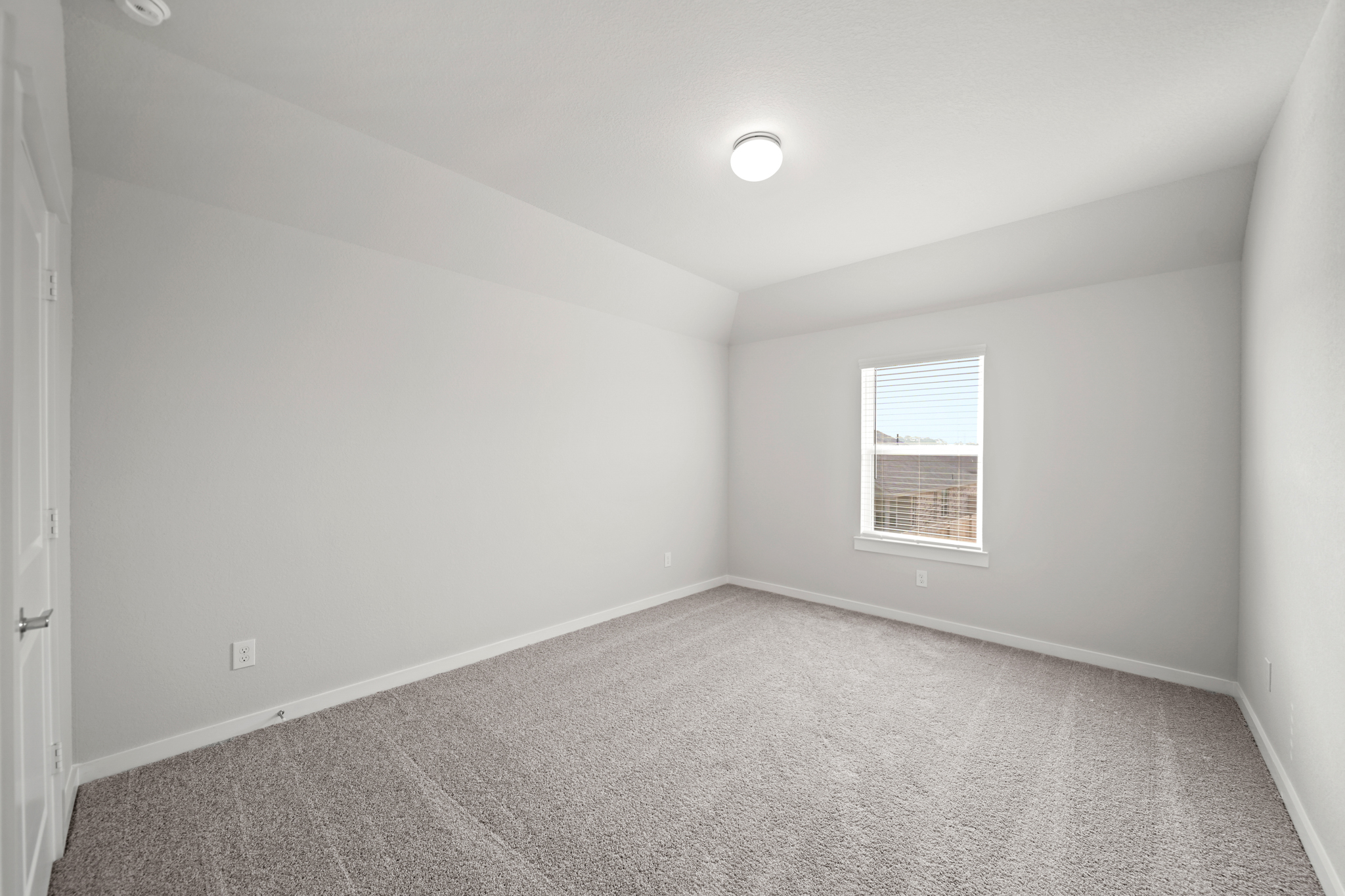 A room with a carpet and a window.