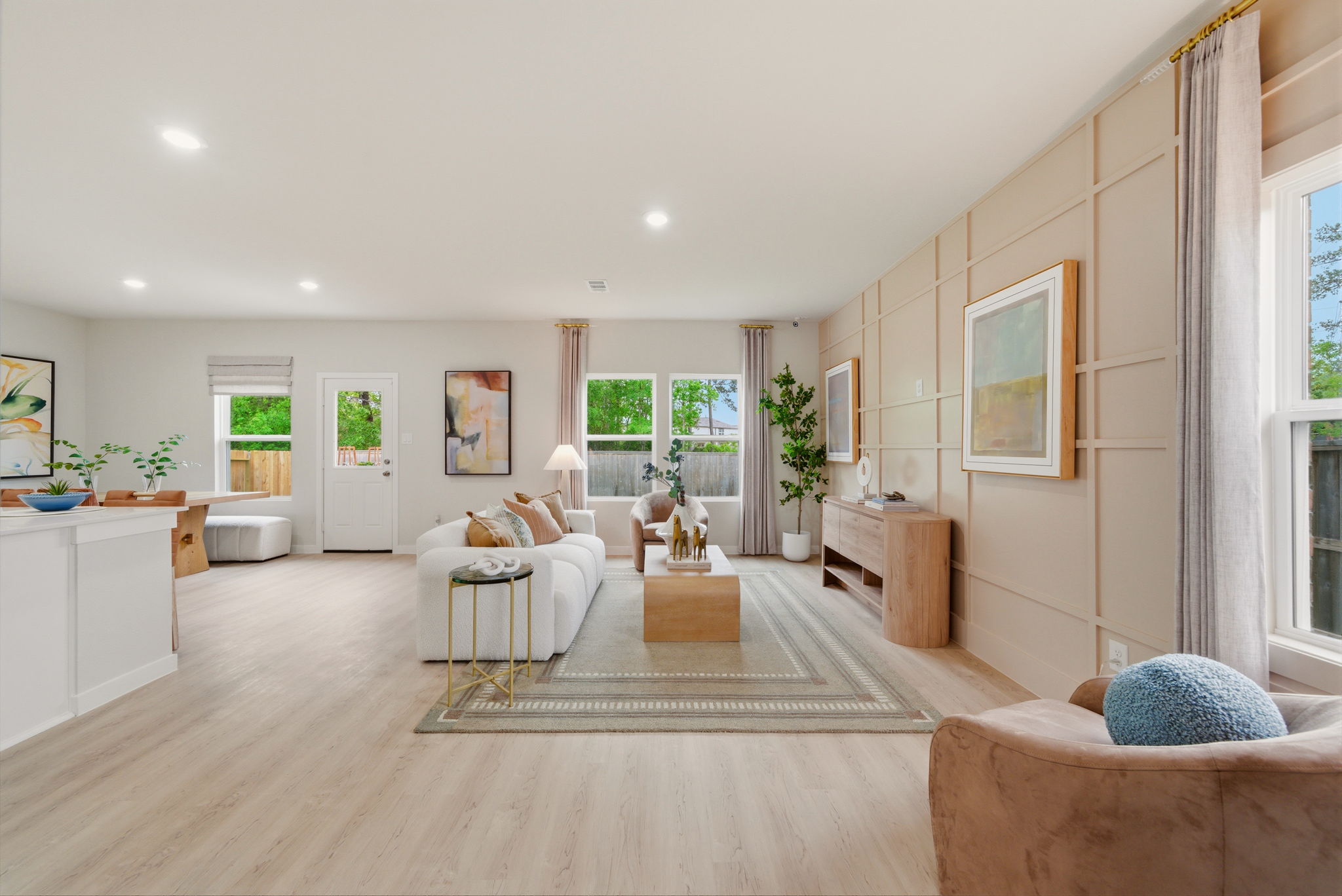 A large living room with a large rug and a large window.