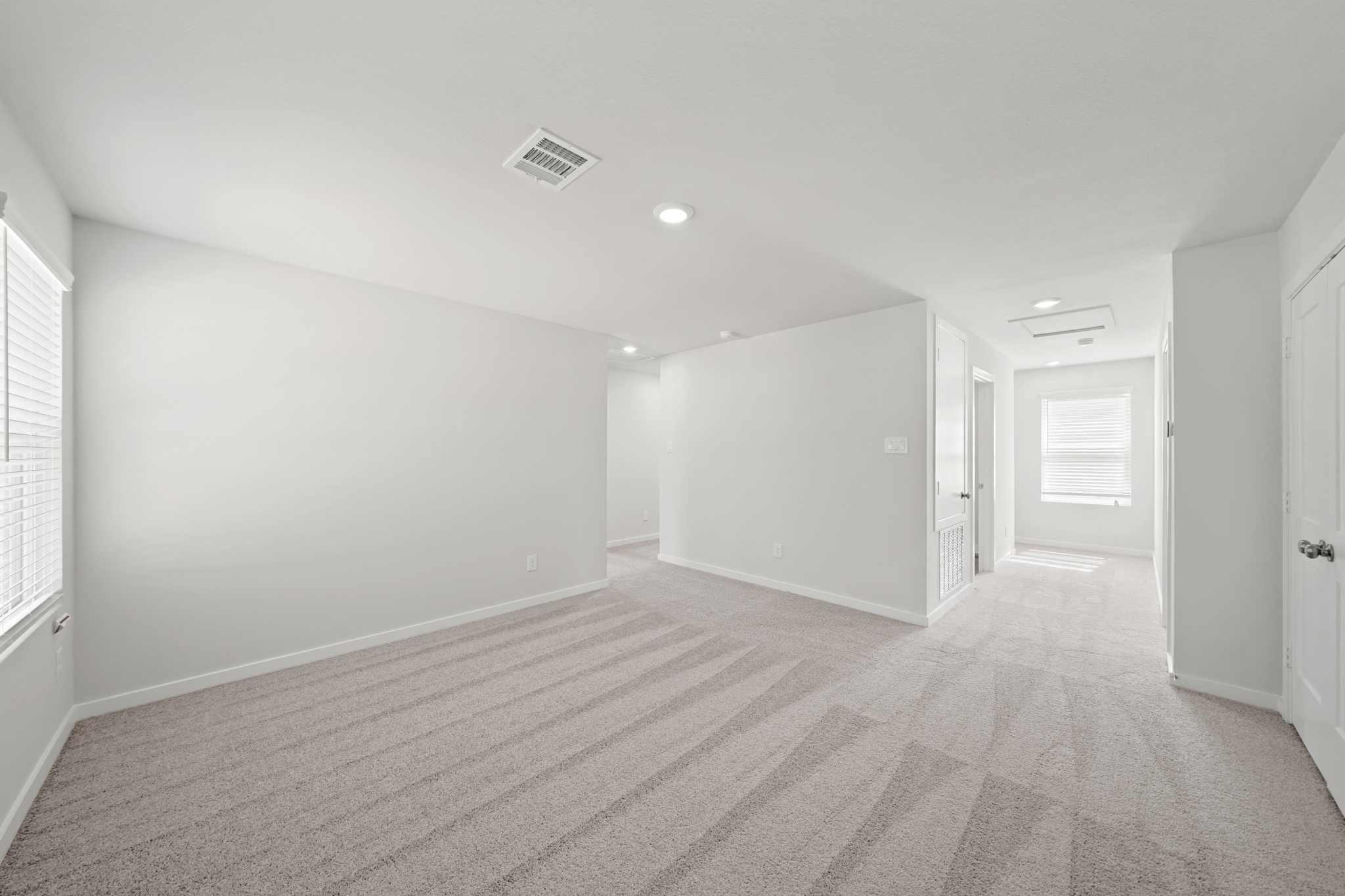 A long hallway with white doors.