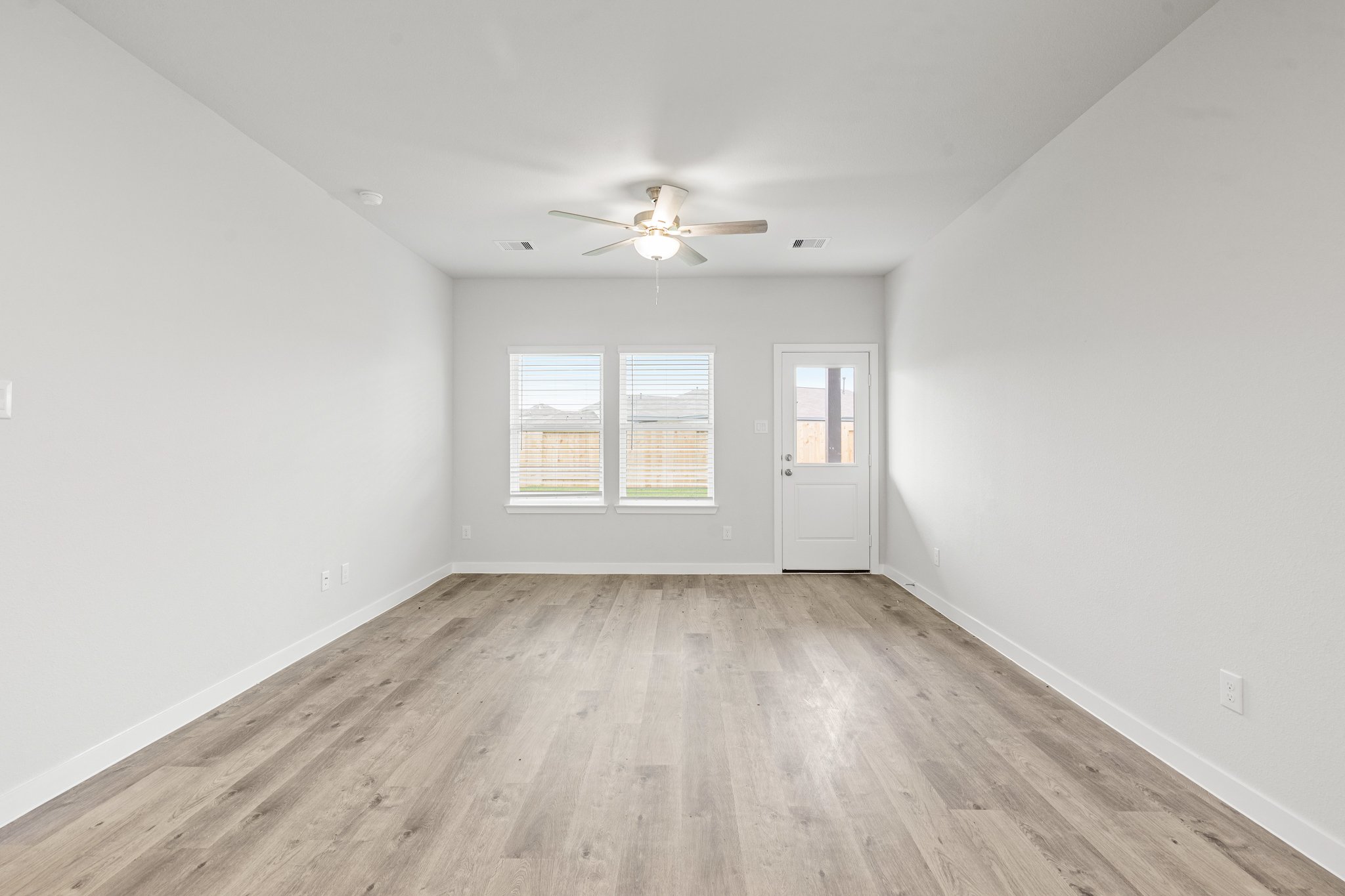 A room with a wood floor and a ceiling fan.
