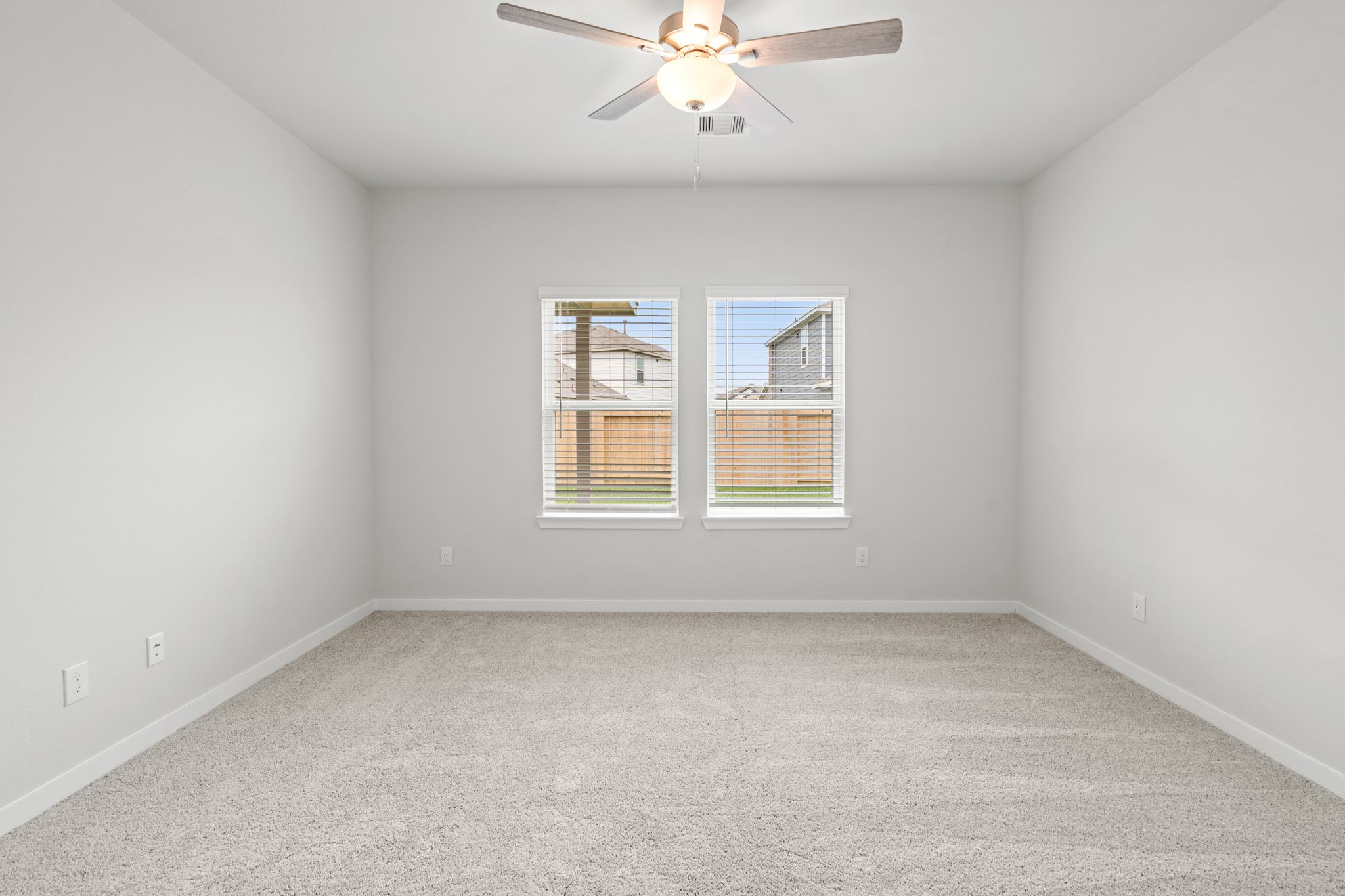 A room with a ceiling fan and a window.
