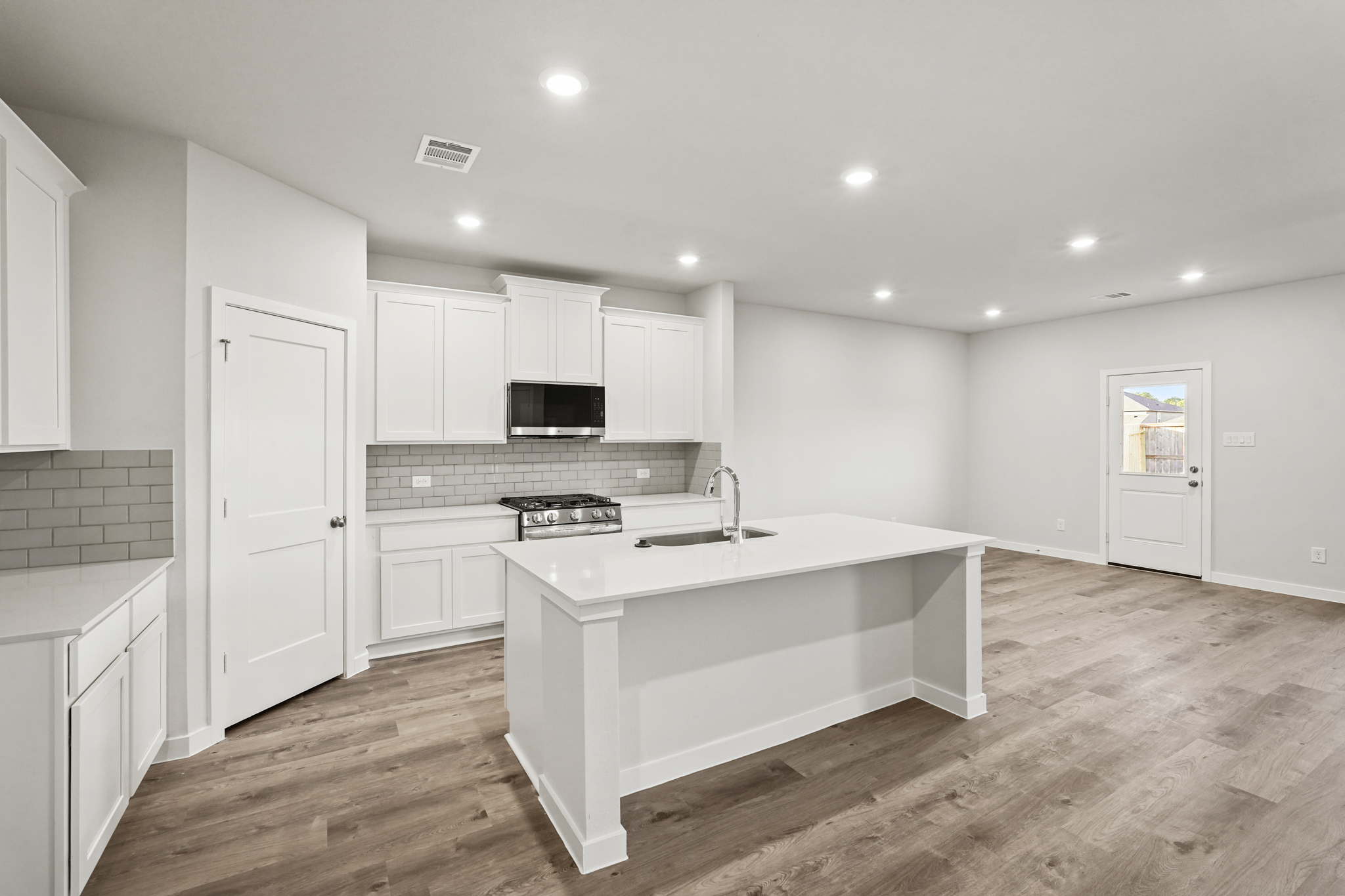 A kitchen with white cabinets.