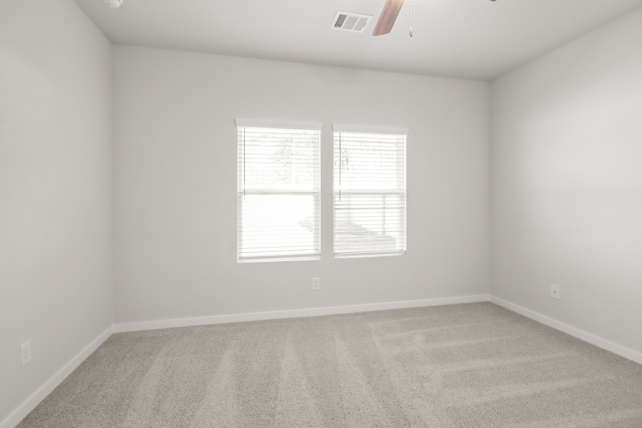 A room with a window and a carpet.