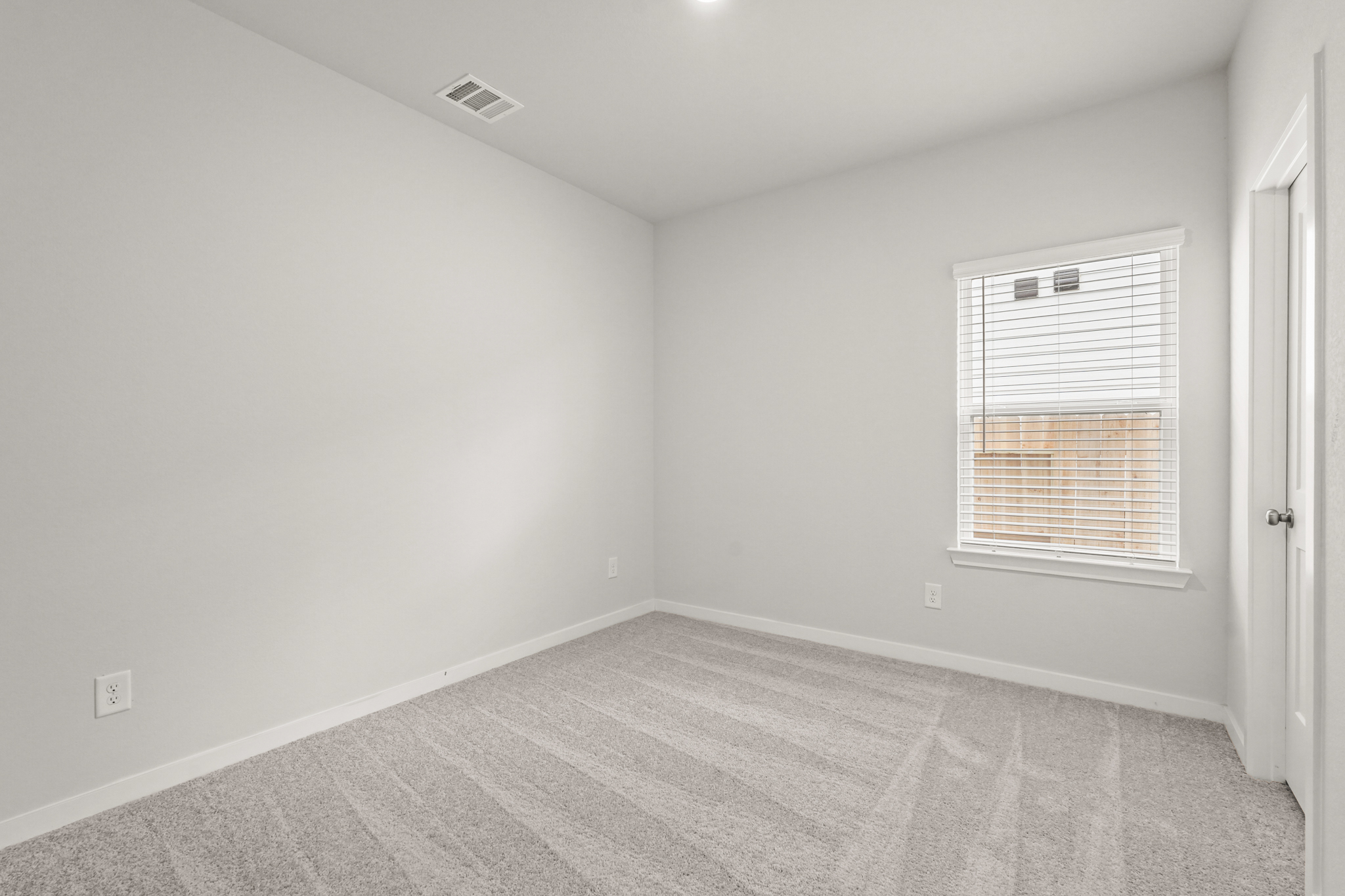 A room with a window and a rug.