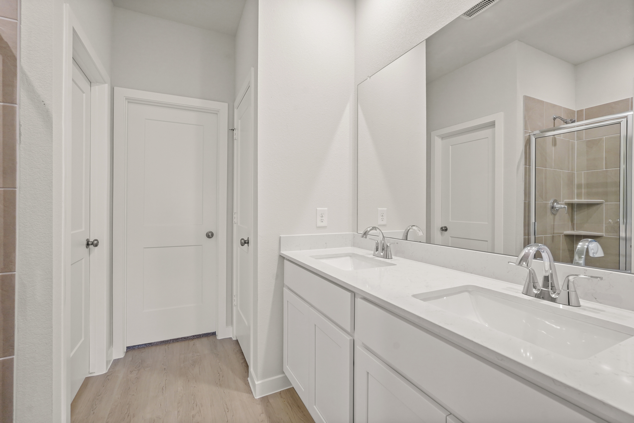 A bathroom with white cabinets.