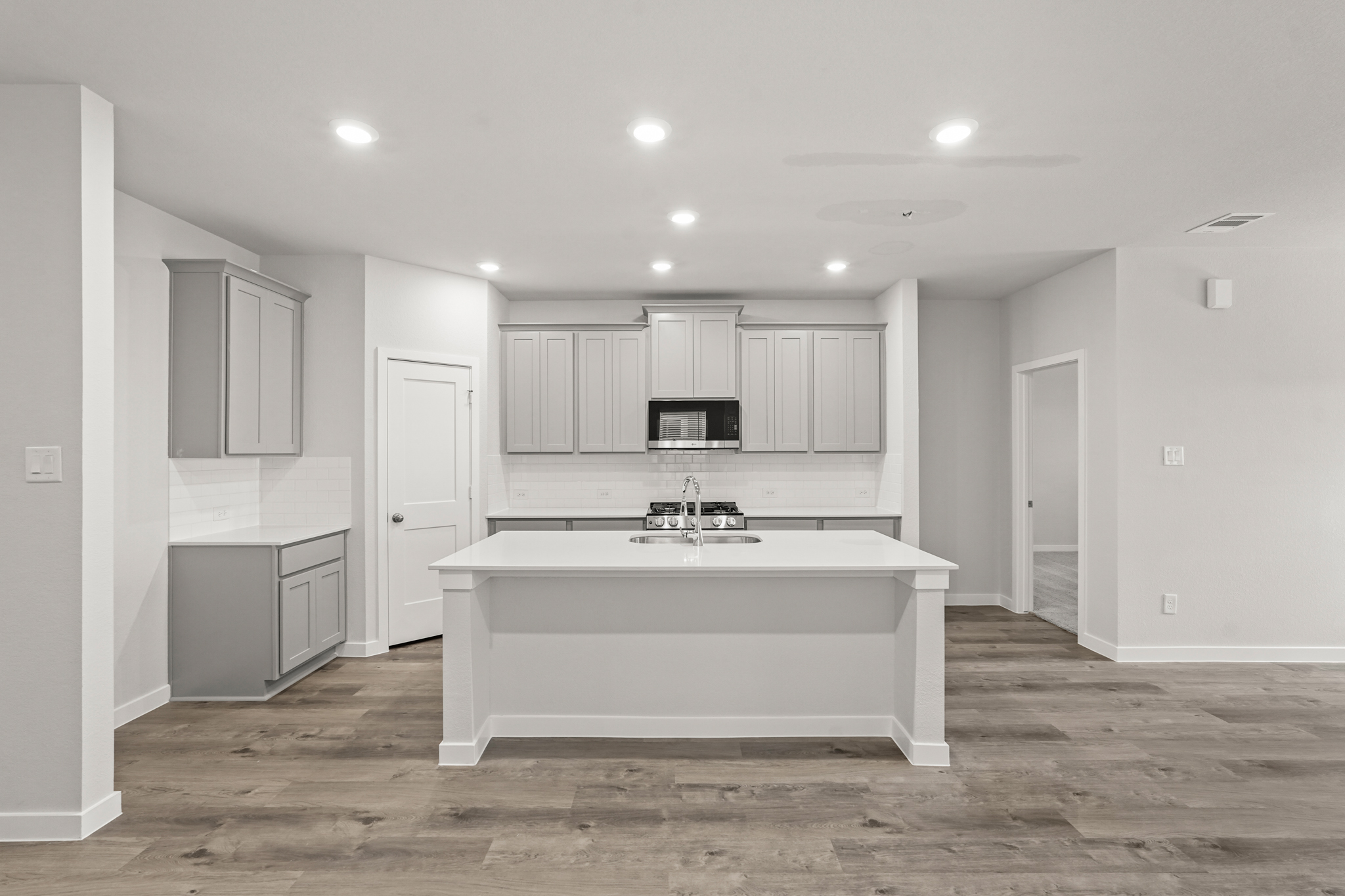 A large white kitchen with white cabinets.