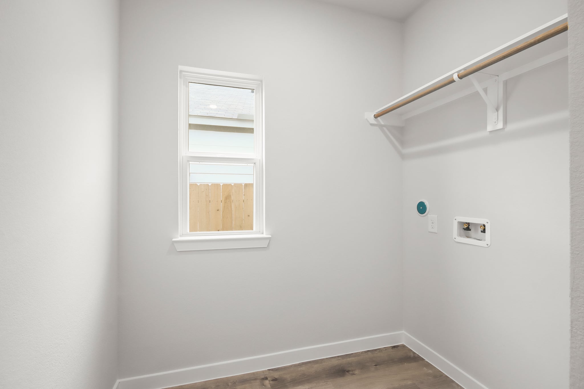A white wall with a window and a white railing.
