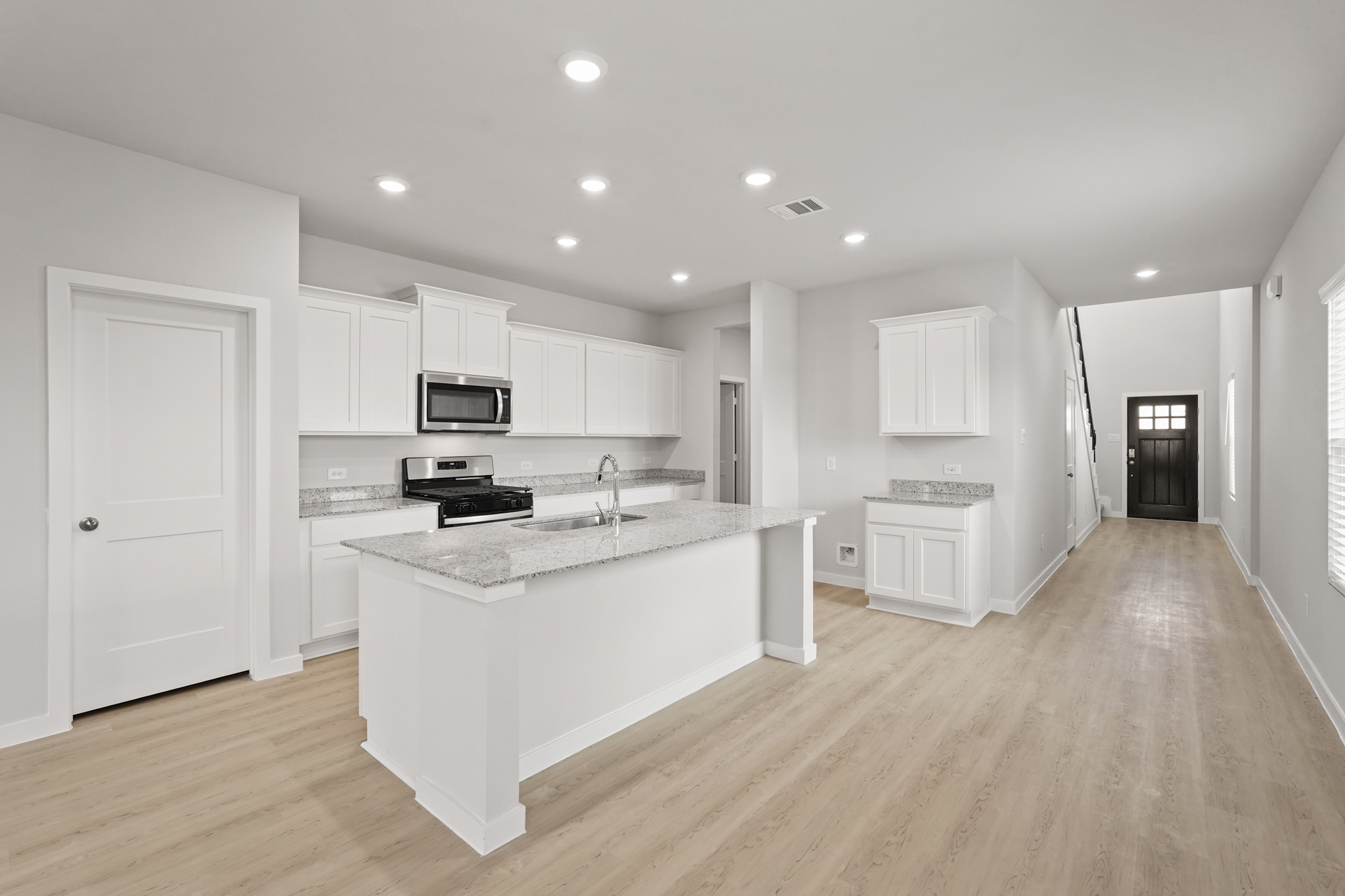 A kitchen with white cabinets.